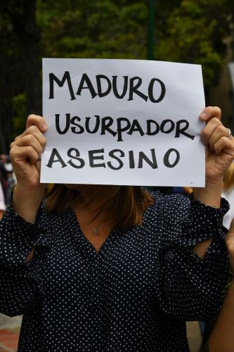 Manifestante muestra afiche contra Maduro