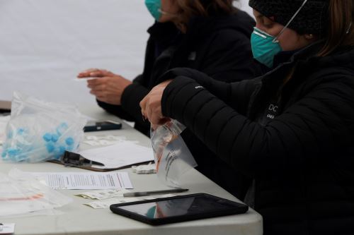 Un miembro de un equipo de respuesta de covid-19 sostiene los kits de prueba en un evento de pruebas en Leesburg, Virginia, el 30 de diciembre del 2021.