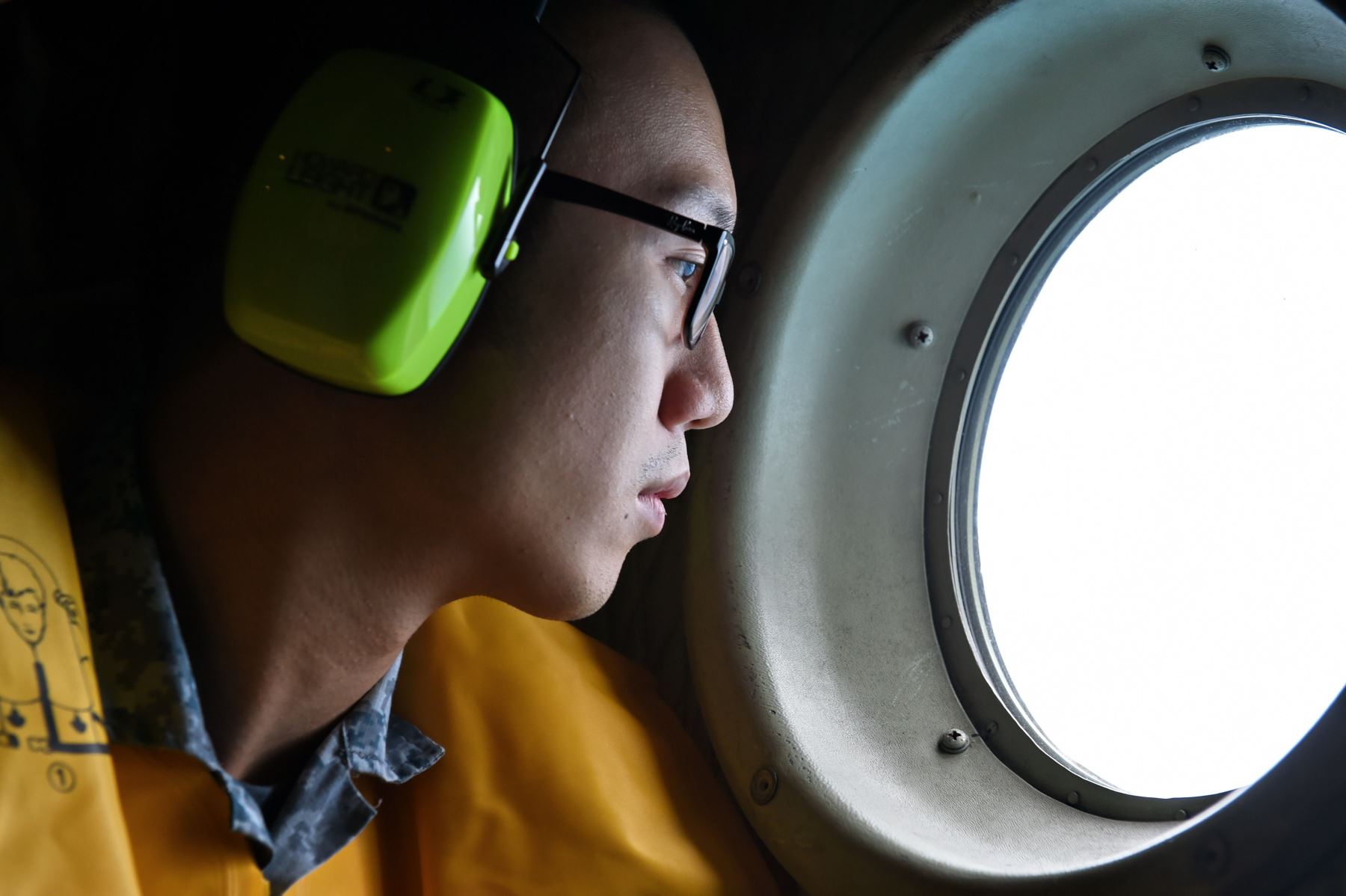 Oficial observa desde un avión durante el proceso de búsqueda de cuerpos del avión de AirAsia. Foto: AFP.