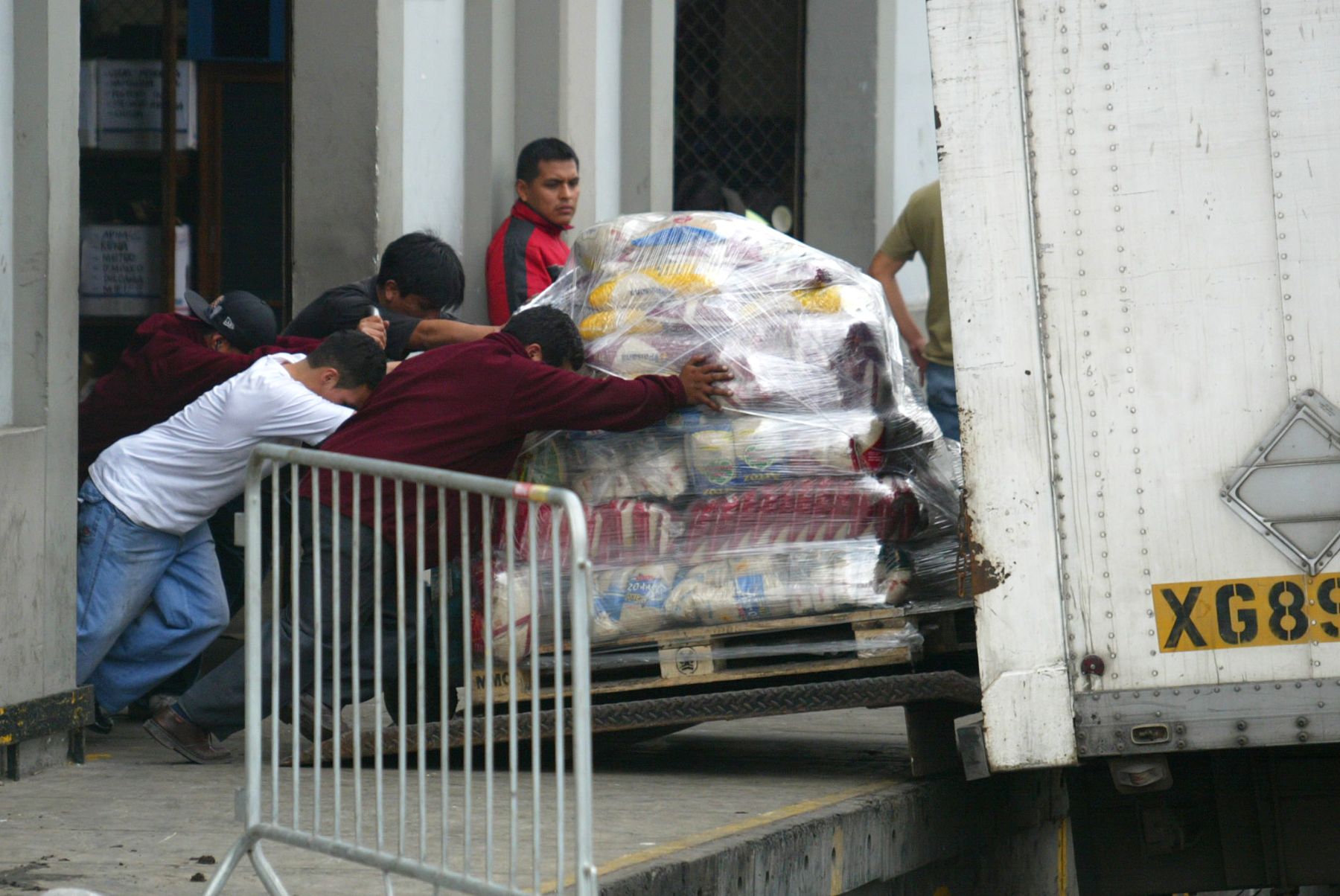 Obreros retiran productos del supermercado y lo introducen en camiones. Foto: ANDINA/Rubén Grández.