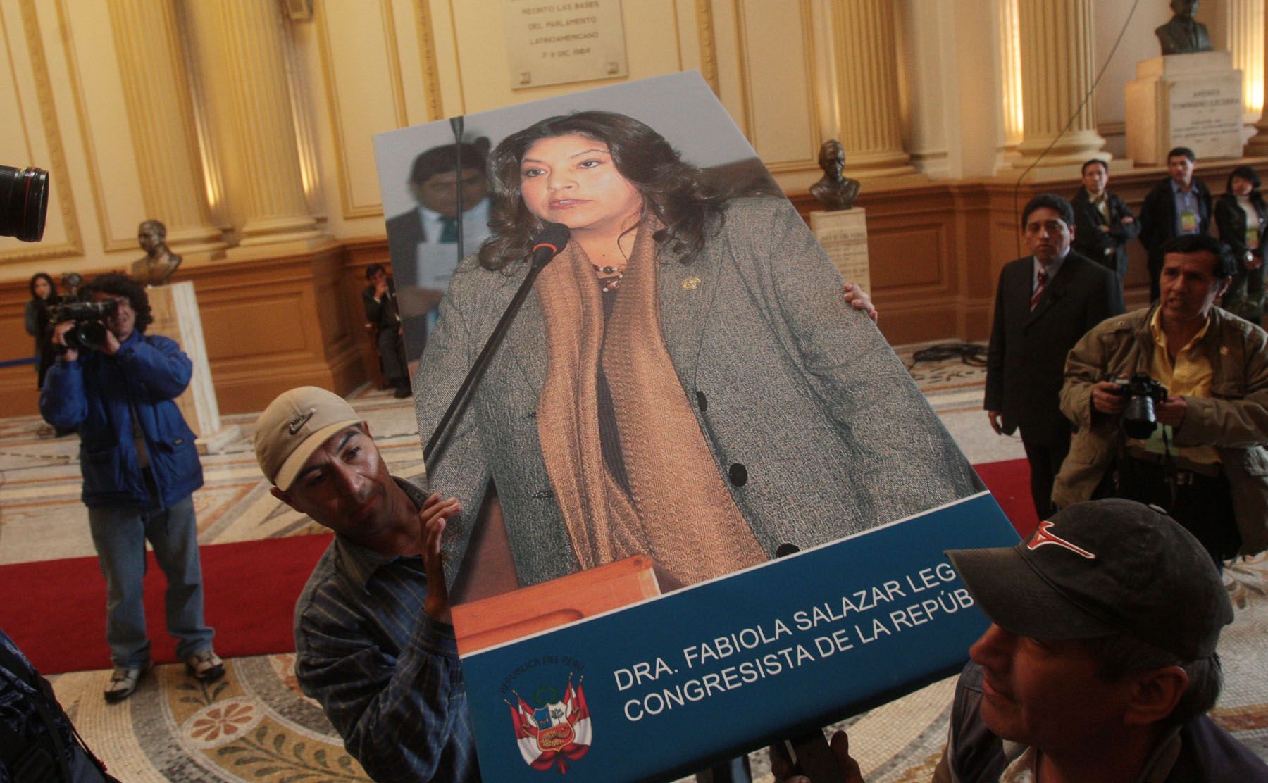 Dos personas trasladan una fotografía de la fallecida congresista Fabiola Salazar, esta mañana en el Congreso de la República. Foto: ANDINA / Carlos Lezama.