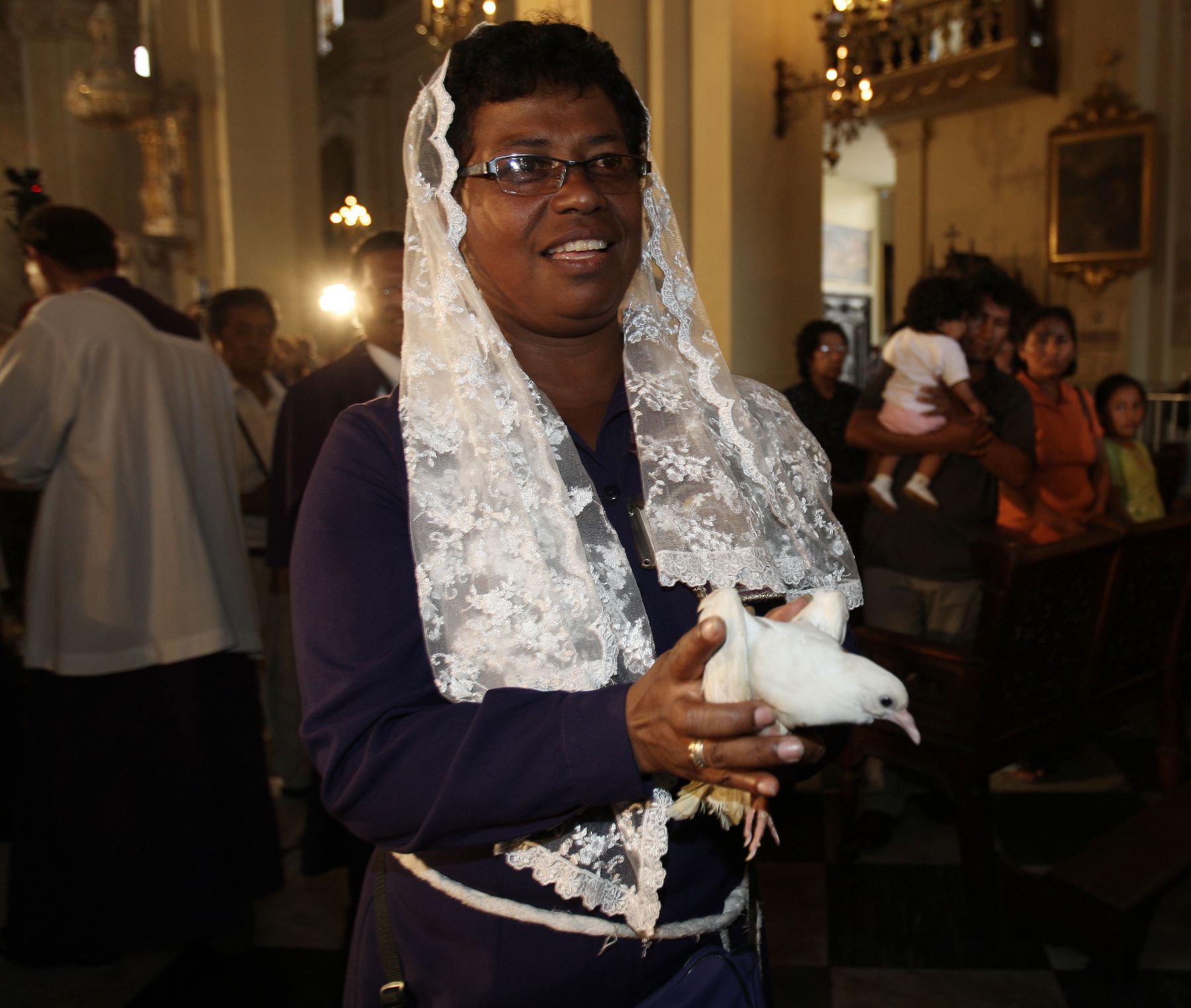 Saumadora del Señor de los Milagros lista para soltar una paloma blanca en el interior de la Catedral de Lima, luego que la procesión del Cristo Morado recorriera el centro de la capital en Viernes Santo. Foto: ANDINA/ Norman Córdova