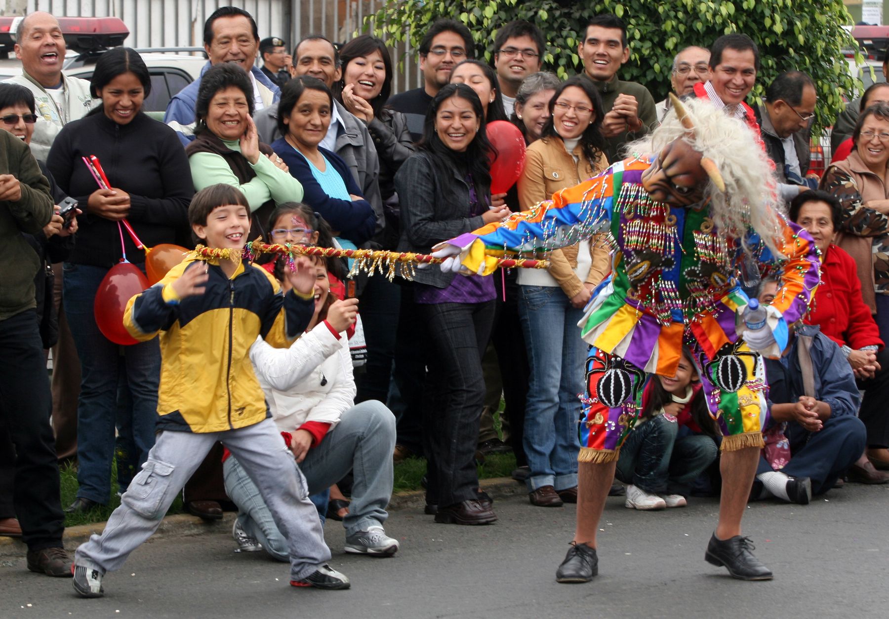 Un niño juega con un danzante durante el pasacalle "Celebra Perú", que recorre esta mañana la avenida Brasil. 
Foto: ANDINA/Rocío Farfán