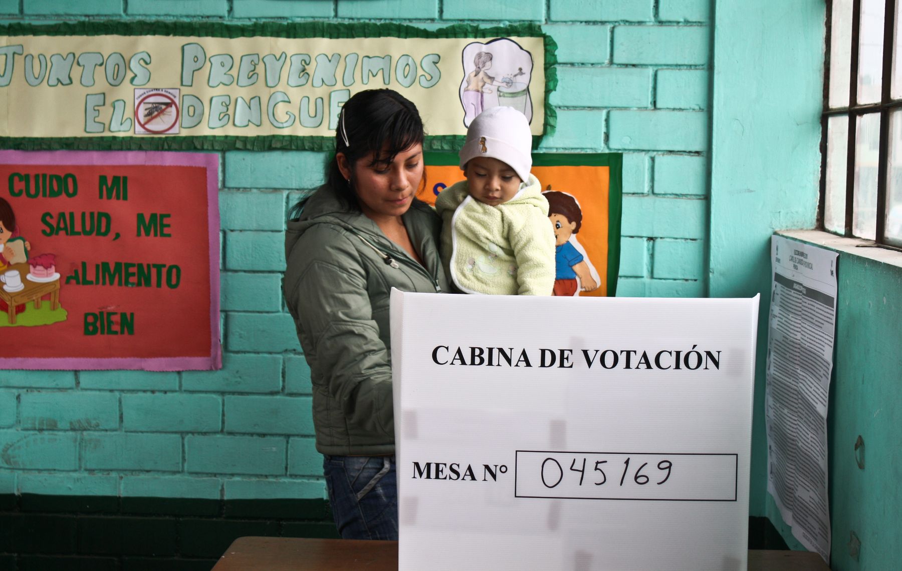 Con su bebe en brazos una madre de familia acude a votar a un centro esclar del Cono Norte de Lima, en las Elecciones Municipales 2010
Foto: ANDINA/Jack Ramón