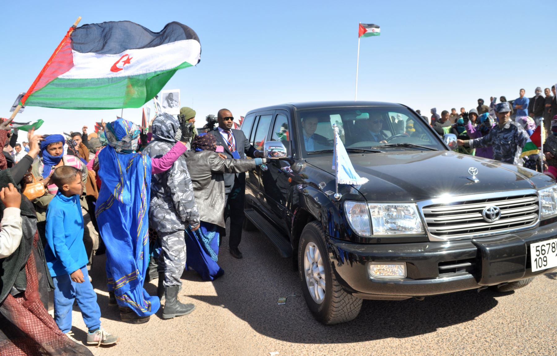 Hombres saharauis ondean banderas tras la llegada del Secretario General de la ONU en el campo de refugiados de Smara en la provincia de Argelia. Foto: AFP