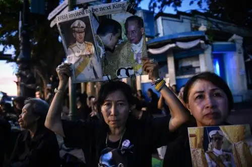 Tailandeses con retratos del nuevo rey de Tailandia, Maha Vajiralongkorn, y su padre, el fallecido Bhumibol Adulyadej, junto al Gran Palacio en Bangkok. AFP