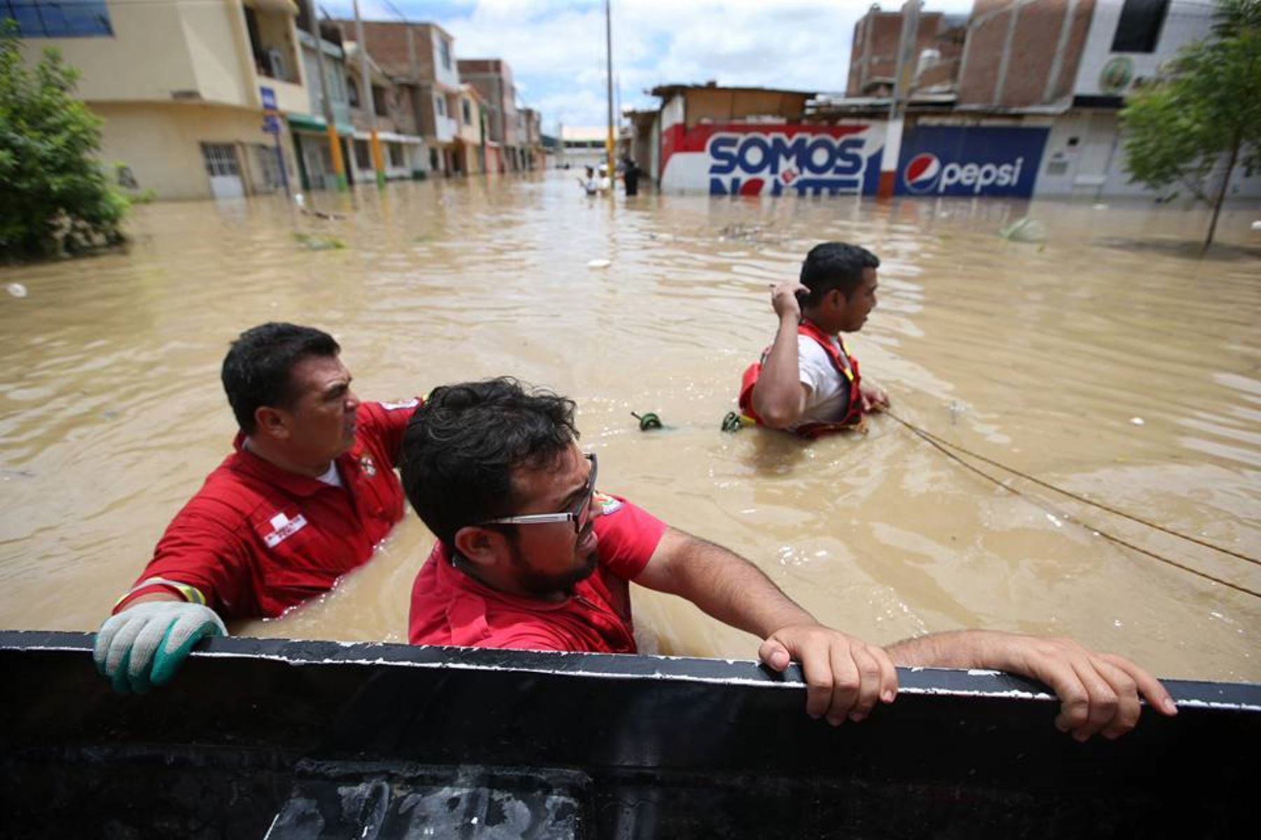 Población afectada por desborde del río Piura en el distrito de Castilla, se traslada por las calles inundadas.
