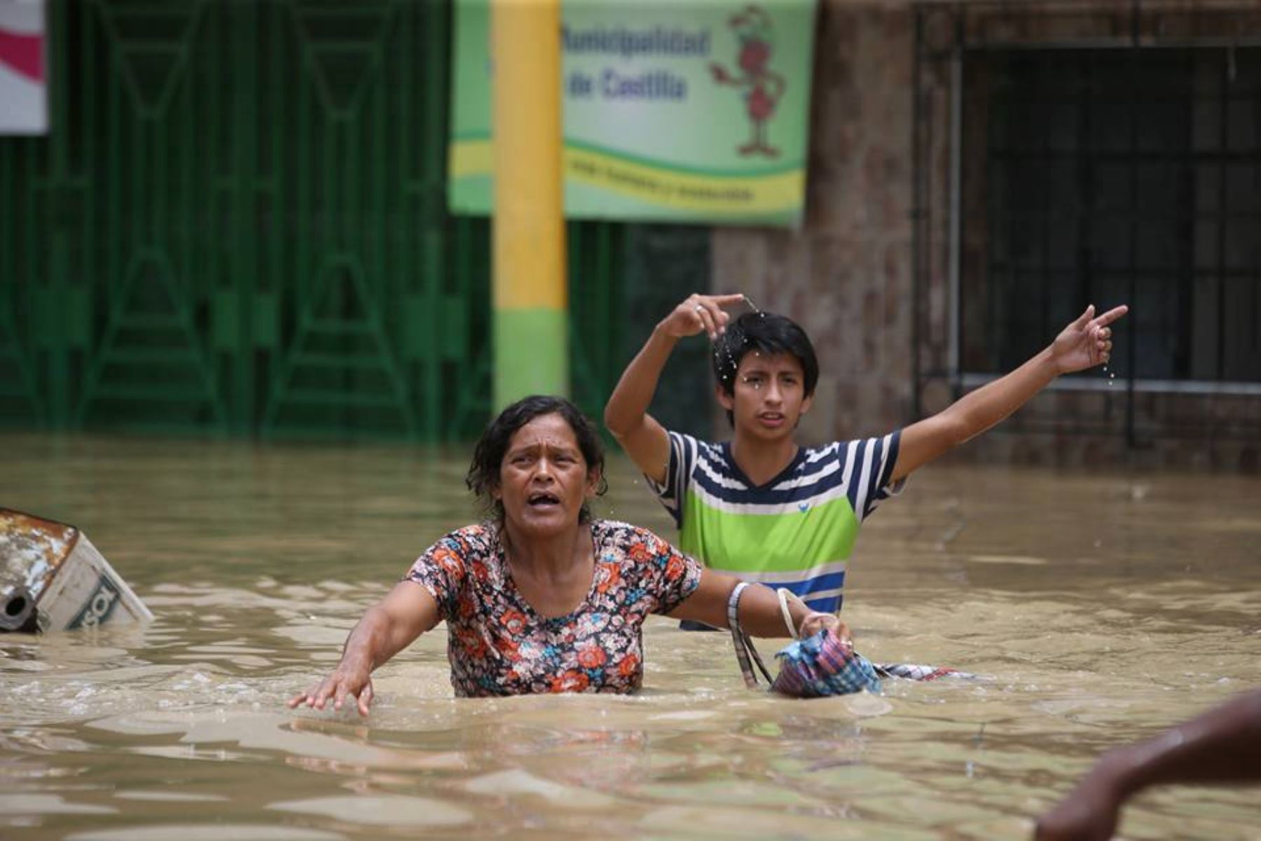 Población afectada por desborde del río Piura en el distrito de Castilla, se traslada por las calles inundadas.