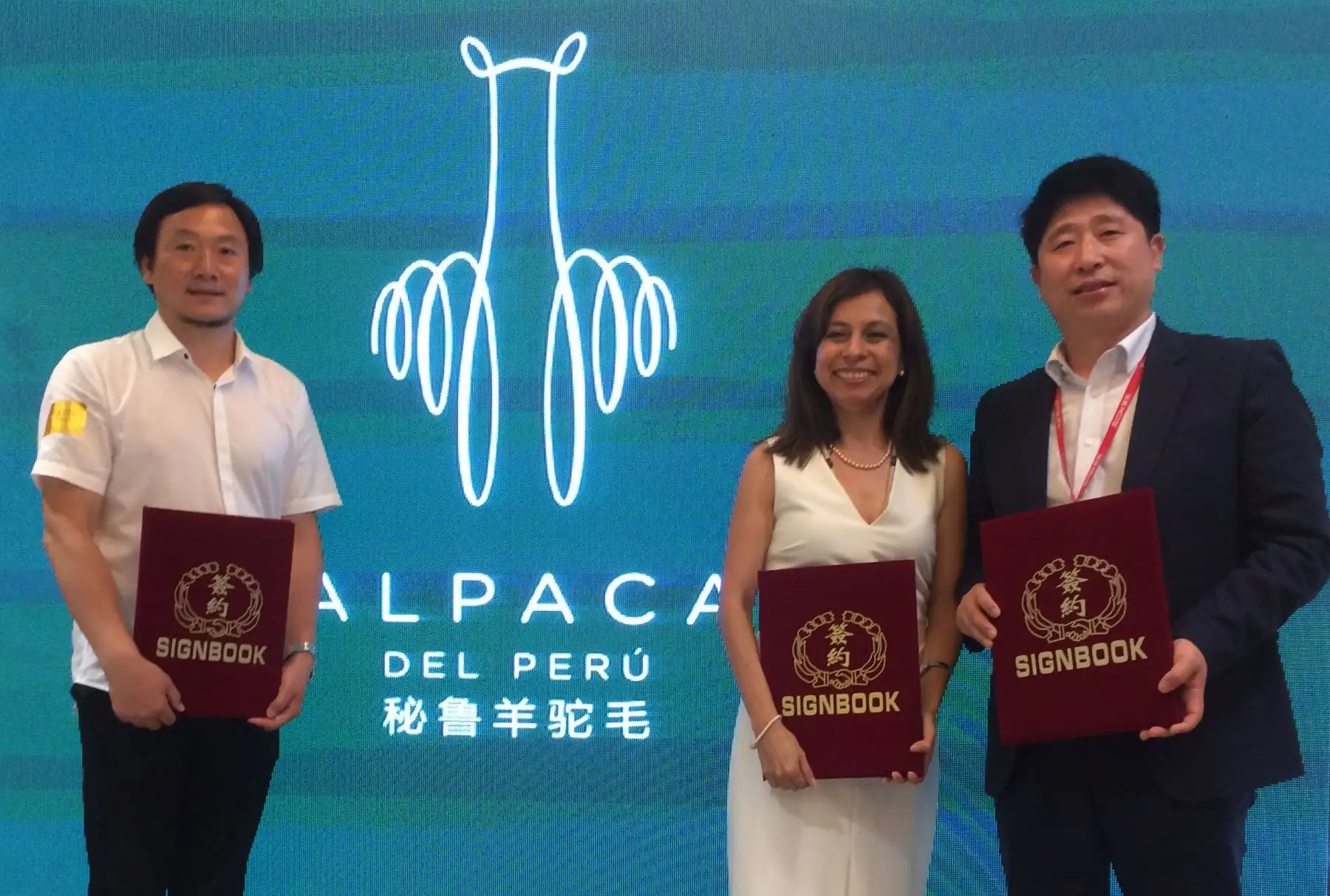 Vicepresidente del Instituto Tecnológico de la Moda de Beijing (BIFT por sus siglas en inglés), Ronglin Jia; la consejera económica comercial de Perú en Beijing, Diana Pita, y el vicepresidente de la plataforma electrónica Jingdong, Yuechuan Qu, con el fondo de la marca Alpaca del Perú. Foto: Julio Panduro.