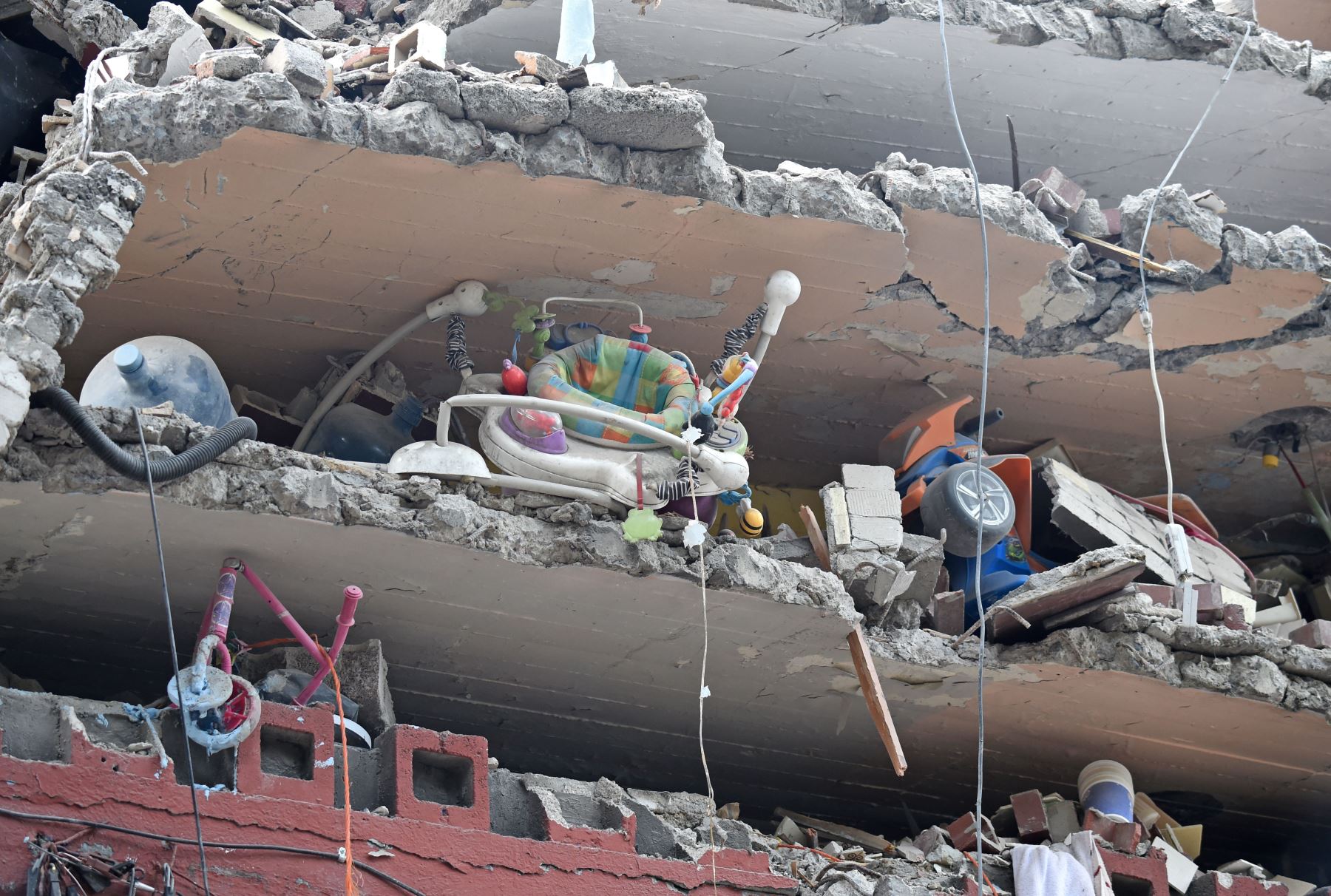 Juguetes y un andador son vistos en un edificio aplastado por el fuerte terremoto que azotó el centro de México. Foto: AFP