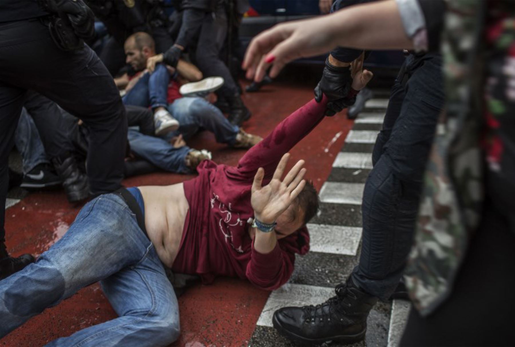 Agentes de policía españoles inmovilizan a algunas personas fuera de una mesa de votación en Barcelona. Foto: AFP