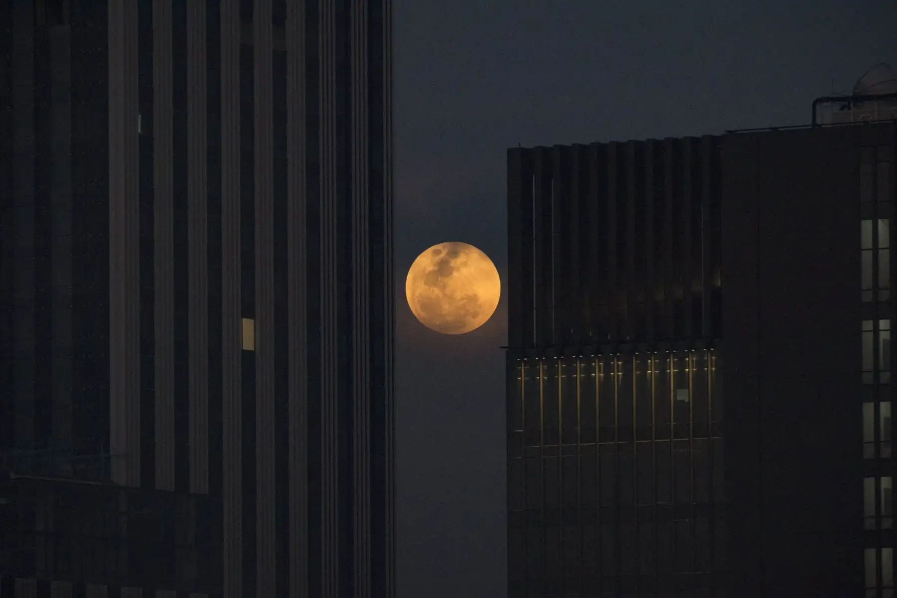 La luna se levanta entre dos edificios de oficinas en Bangkok. Foto: AFP