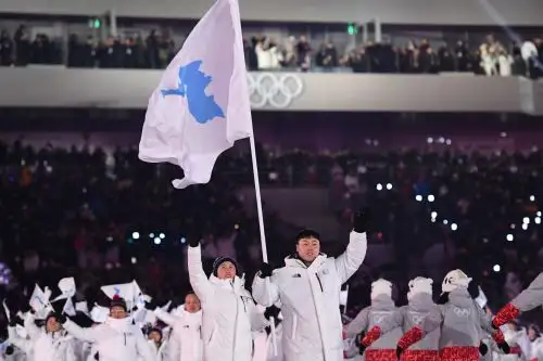 Los abanderados de las dos Coreas desfilan juntos con la bandera de una Corea unificada. Foto: AFP