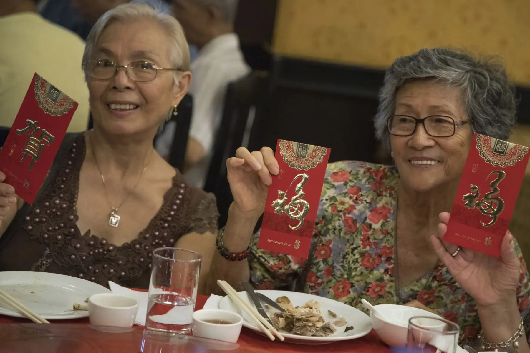 Adultos mayores muestran contentos los sobres rojos o Hong Bao con dinero.Foto: ANDINA/Carlos Lezama