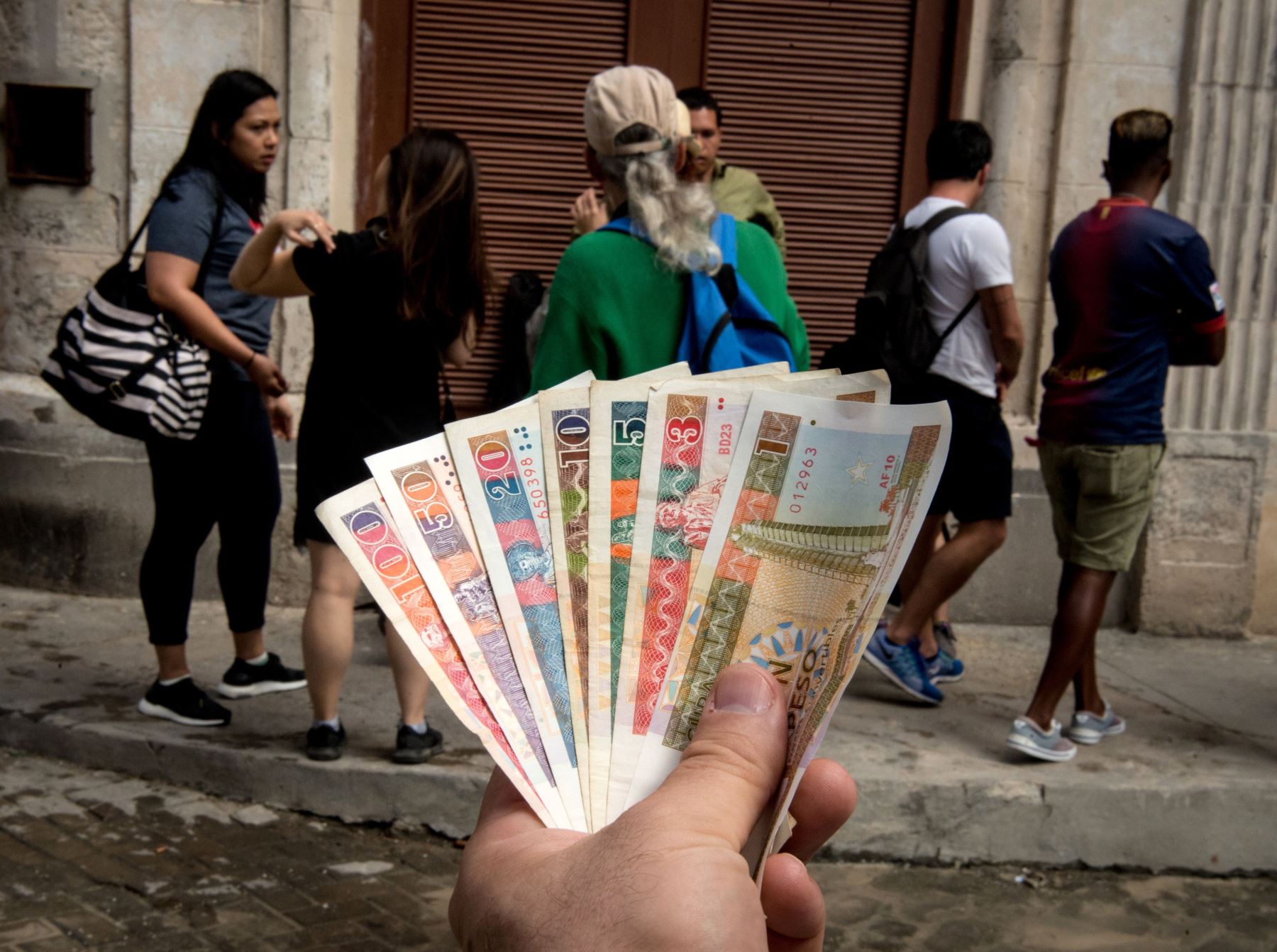 Cubano muestra pesos cubanos convertibles. Foto: AFP.