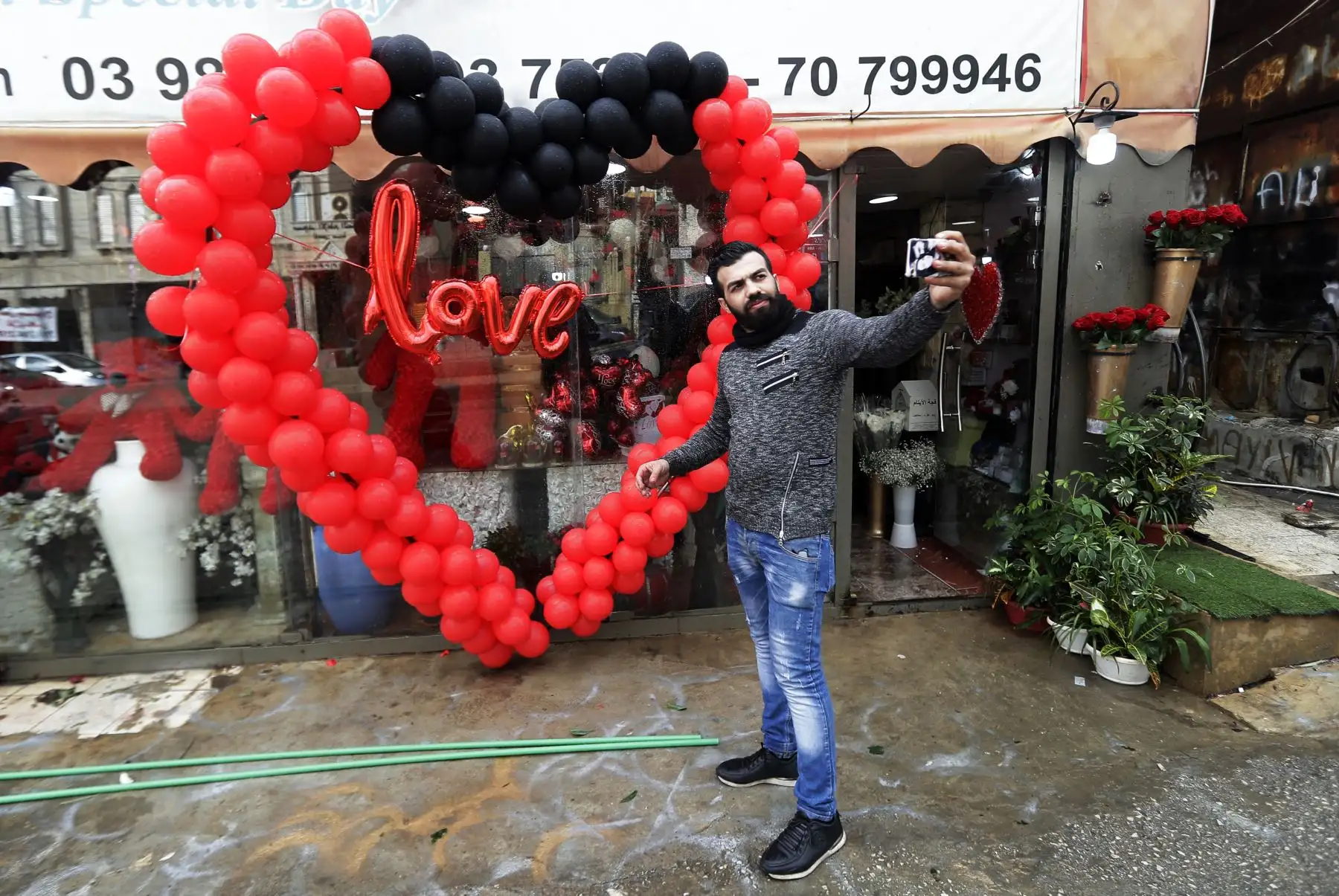 Un vendedor de flores libaneses se toma una selfie frente a su tiendaen Beirut. Foto: AFP