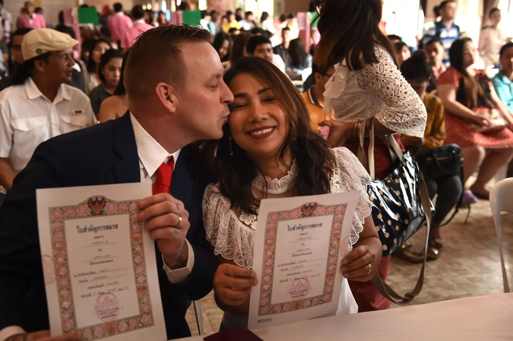 Una mujer tailandesa y un británico sostienen sus certificados de matrimonio el día de San Valentín. Foto: AFP