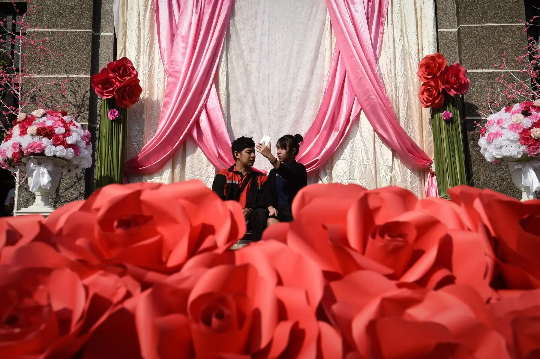 Una pareja se toma selfies con una exhibición de San Valentín en Bangkok. Foto: AFP