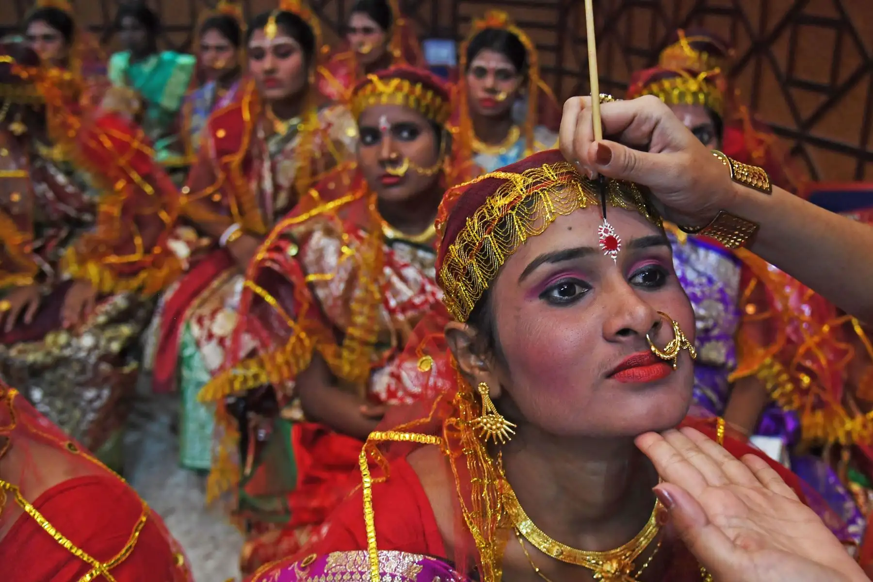 Novias indias esperan el maquillaje final para ceremonia de matrimonio masivo en Calcuta.Foto:AFP