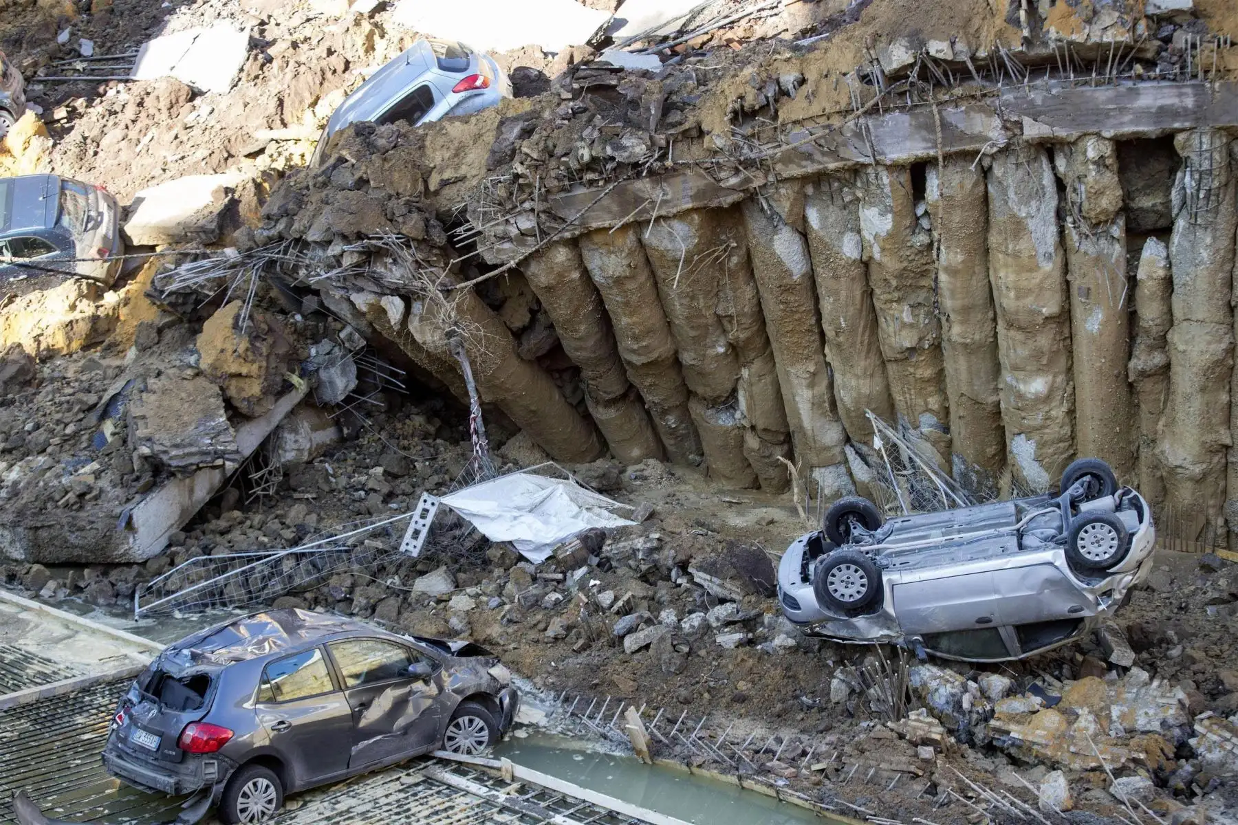 Dos edificios de Roma fueron evacuados después de que la calle en la que se ubican se hundiera formando un enorme socavón que arrastró a varios vehículos. Foto: EFE.