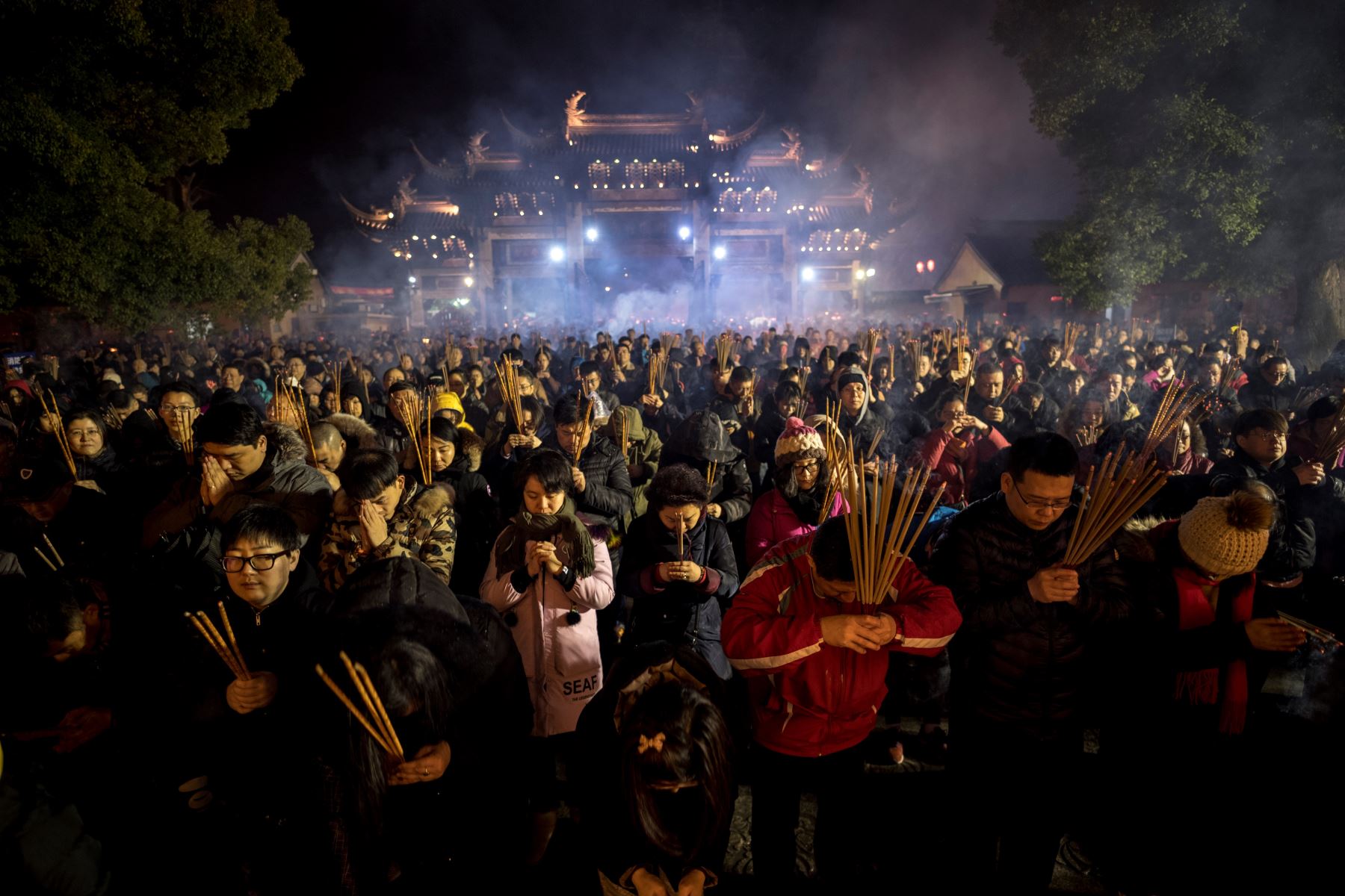 Personas rezan con varillas de incienso para celebrar el Año Nuevo Lunar, en el templo de Longhua en Shanghai. Foto: AFP