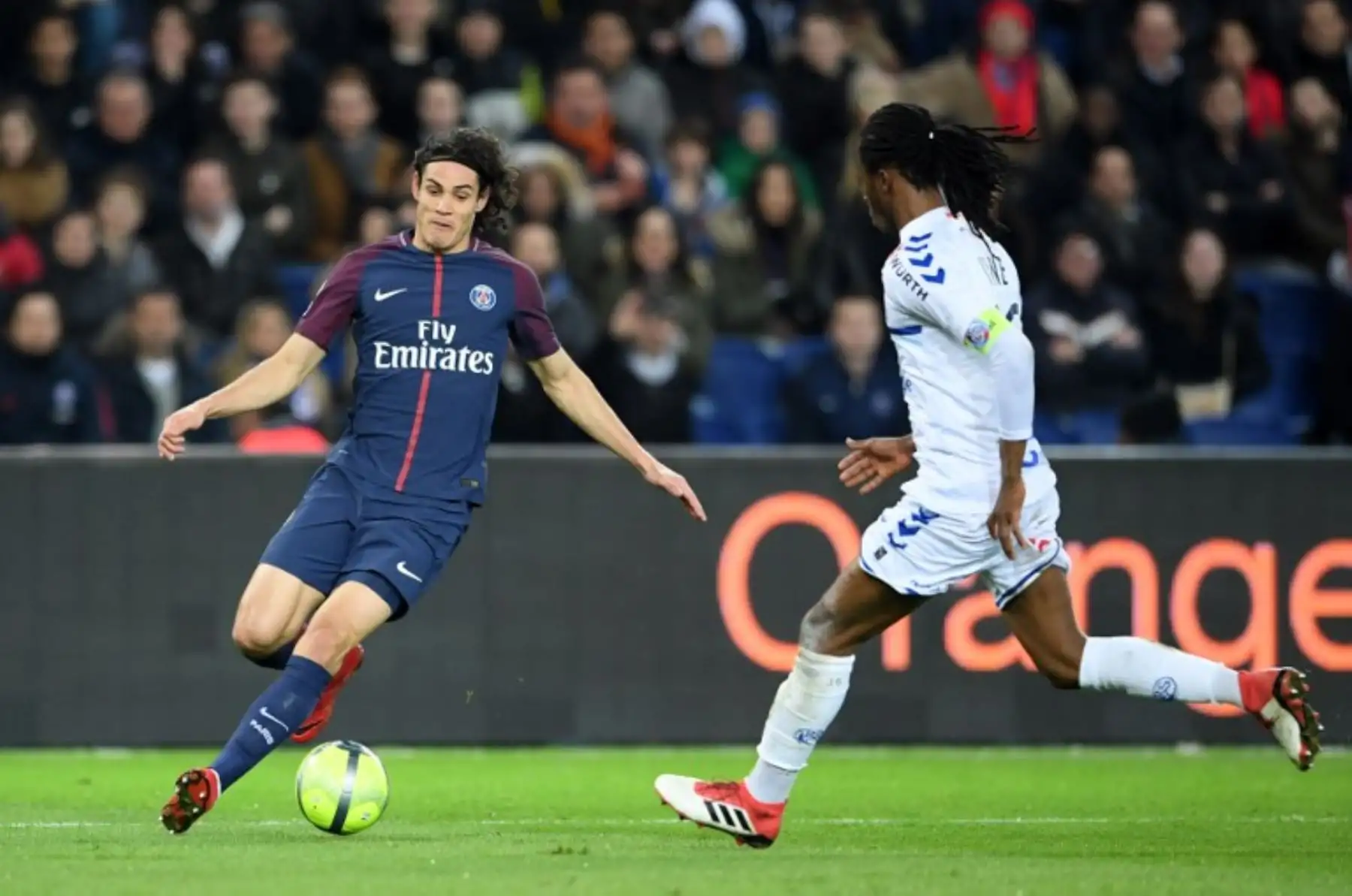 El delantero uruguayo del Paris Saint-Germain Edinson Cavani disputa el balon con el defensa Burkinabe de Estrasburgo Bakary Kone. Foto: AFP