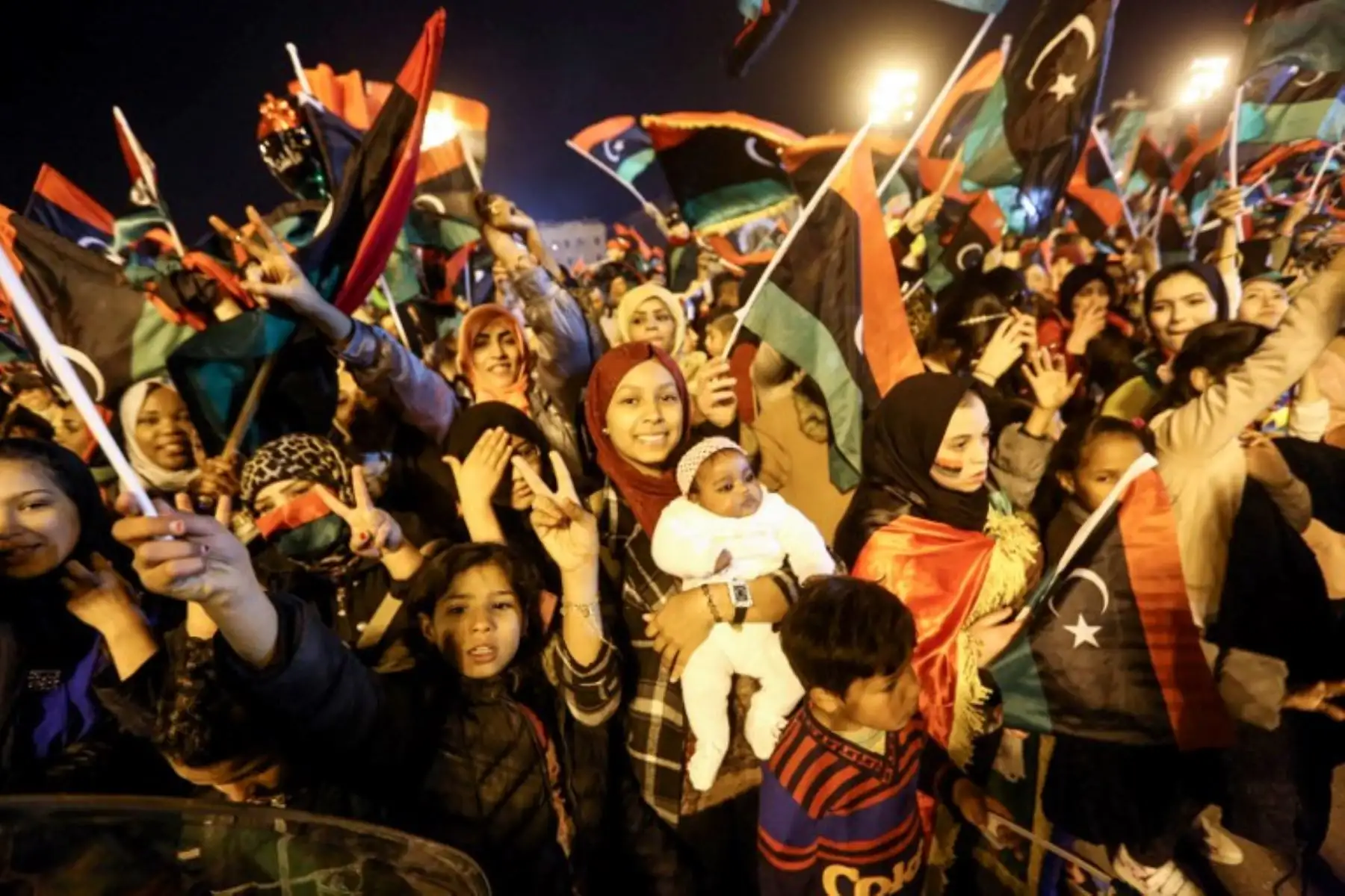 Los libios ondean banderas nacionales en una celebración por el séptimo aniversario de la revolución libia que derrocó al difunto líder Moamer Kadhafi, en la Plaza de los Mártires de la capital, Trípol Foto: AFP