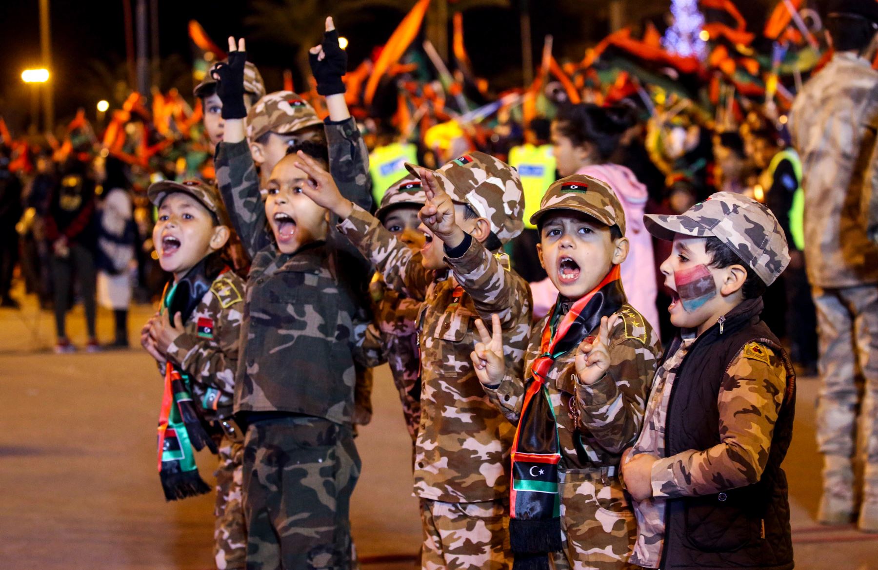 Niños libios con uniformes de camuflaje y pañuelos con los colores de su bandera nacional muestran el gesto de victoria durante la celebración del séptimo aniversario de la revolución libia que derrocó al fallecido líder Moamer Kadhafi.FotoAFP