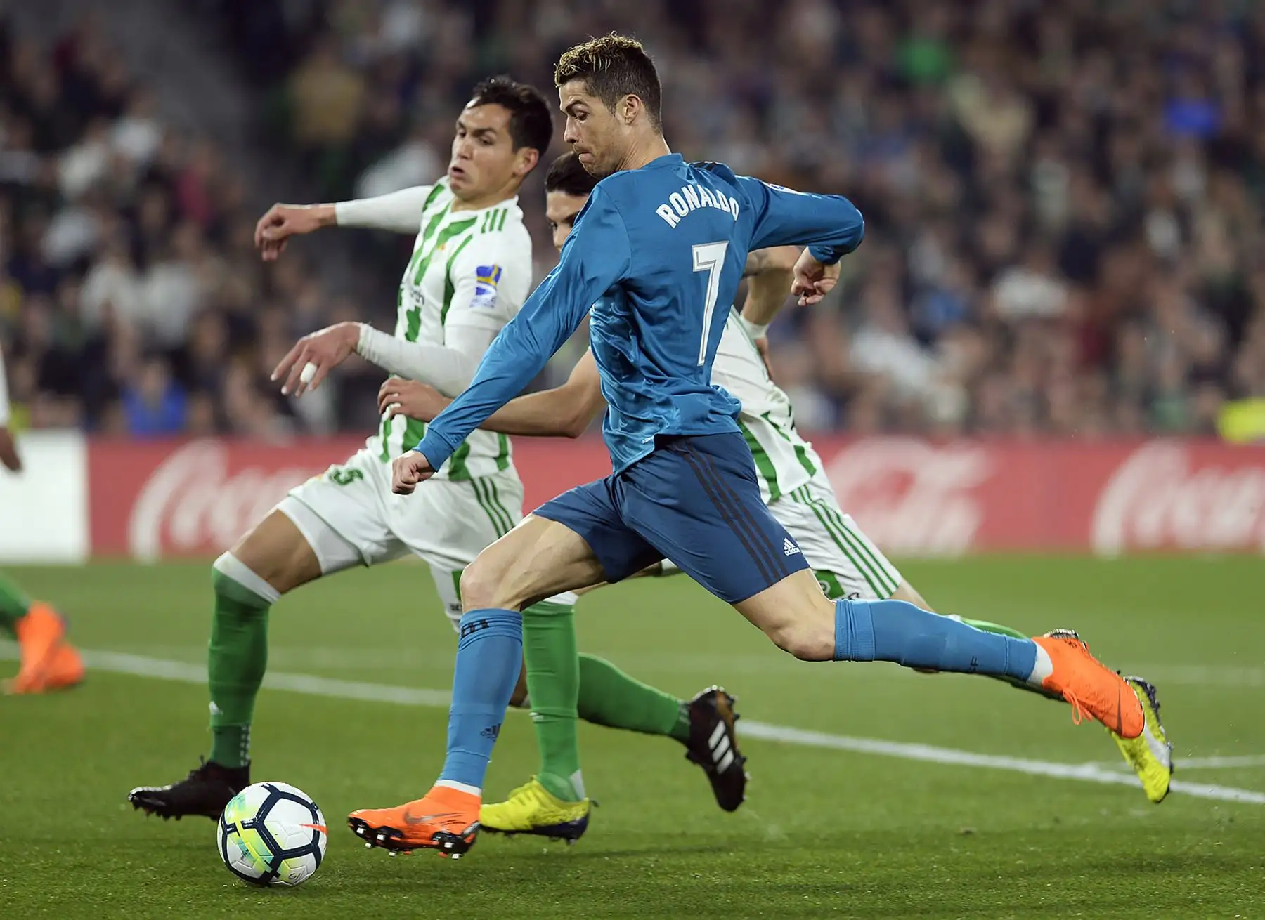 El delantero  del Real Madrid Cristiano Ronaldo  pelea por el balón con el defensa español del Real Betis Marc Bartra durante el partido  de la liga española. AFP