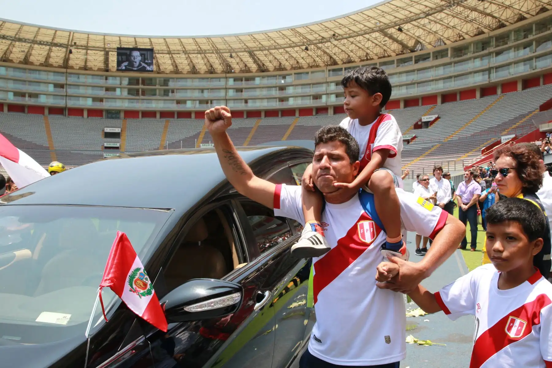LIMA PERÚ - FEBRERO 21. Hincha con su niño en hombros se acerca al  el féretro del  periodista Daniel Peredo para rendirle homenaje en el Estadio Nacional. Foto: ANDINA/Dante Zegarra