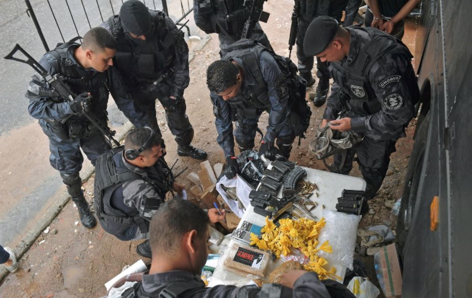 Fuerzas especiales de la policía militar inspeccionan drogas incautadas, armas y municiones, en la favela de Vila Kennedy en Río de Janeiro.Foto:AFP
