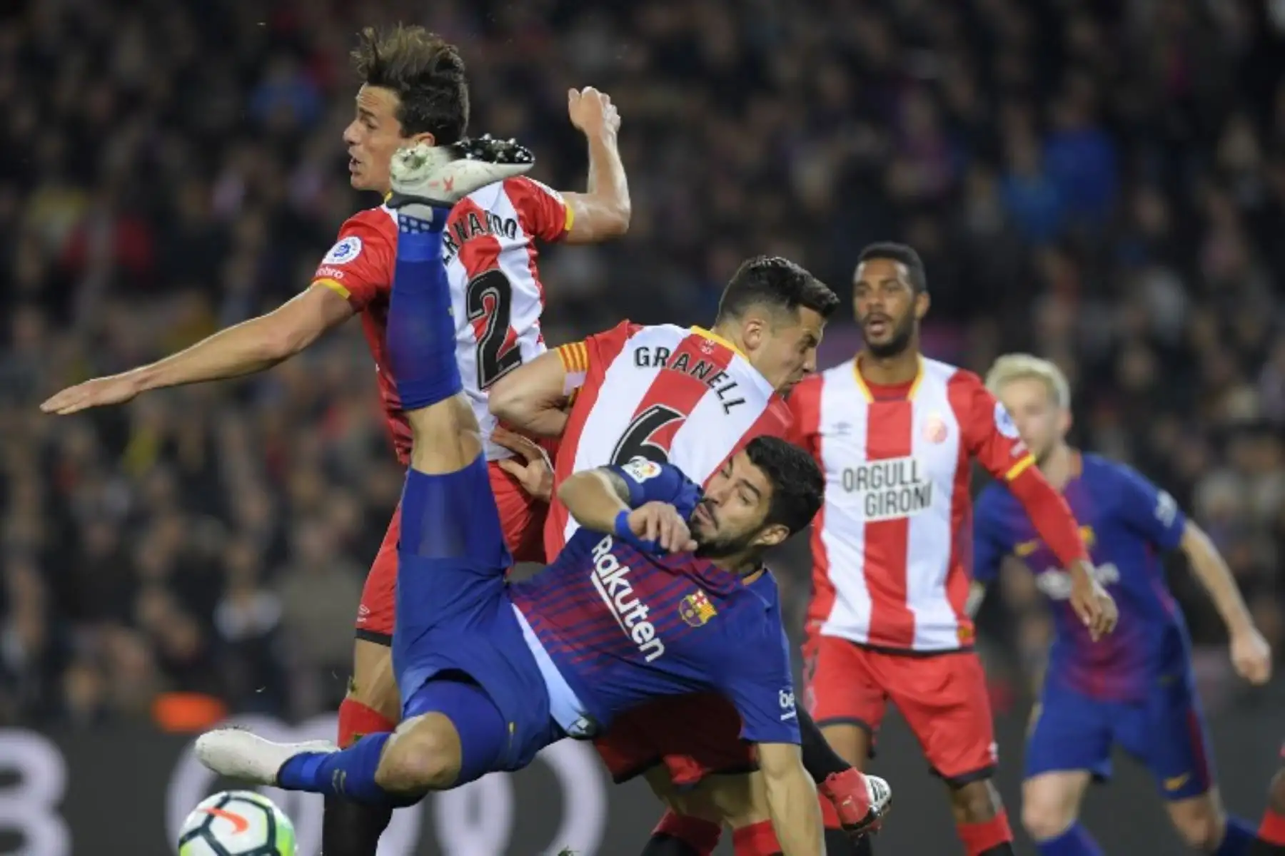 El defensa colombiano Bernardo Espinosa compite con el delantero Luis Suárez durante el partido de fútbol de la liga española entre el FC Barcelona  4 el Girona FC  1.Foto:AFP