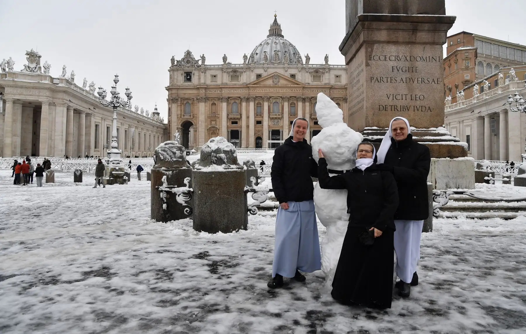 Monjas posan en la plaza de San Pedro cubiertas de nieve. Foto: AFP
