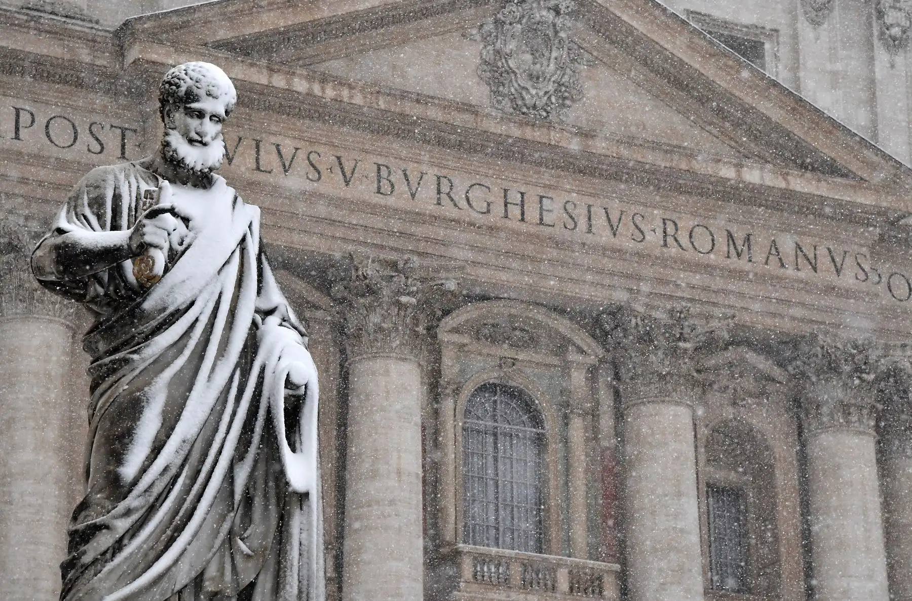 Una estatua es cubierta por nieve frente a la basílica de San Pedro. Foto: AFP