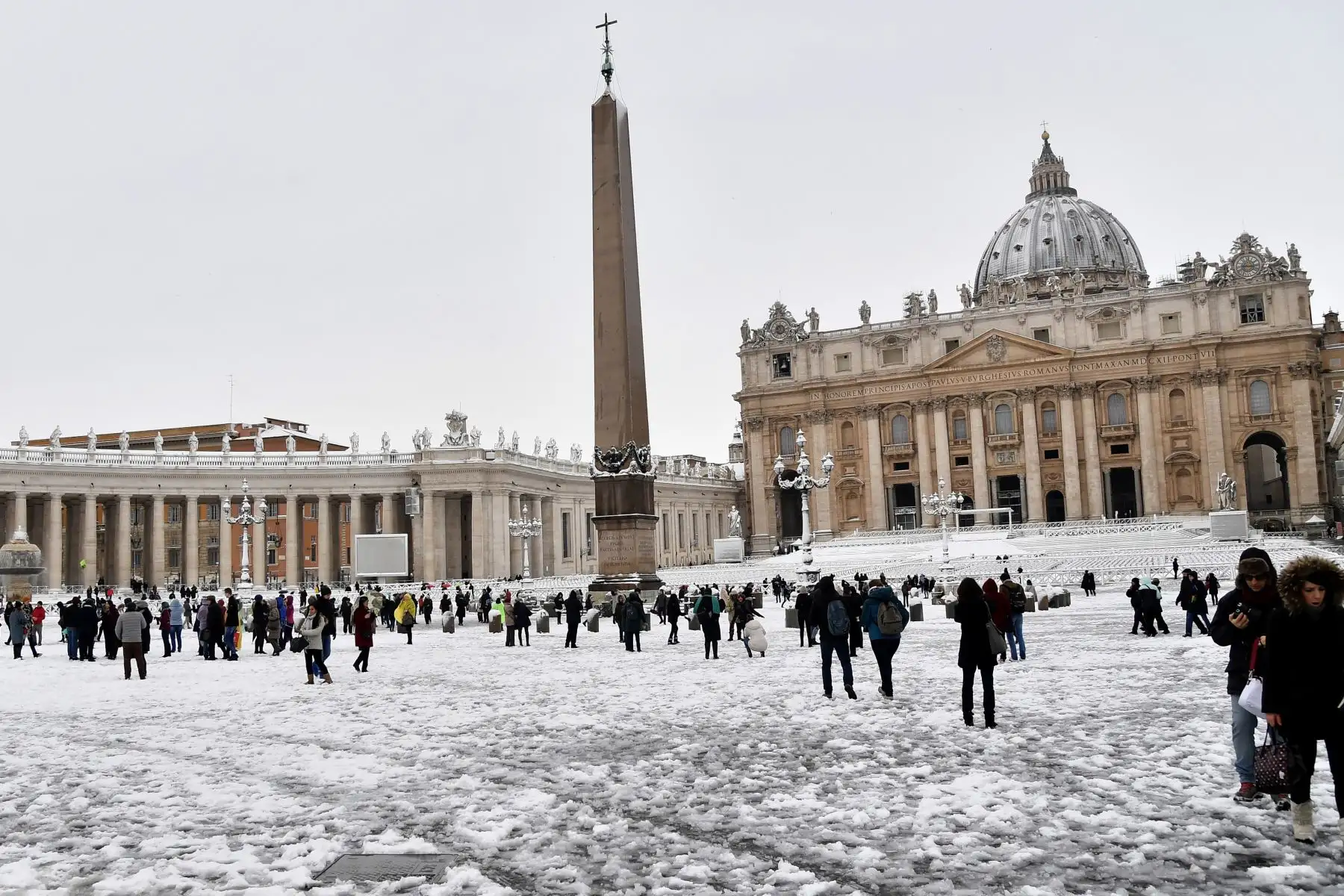 Personas camina en la plaza de San Pedro cubierta de nieve  en el Vaticano.Foto: AFP