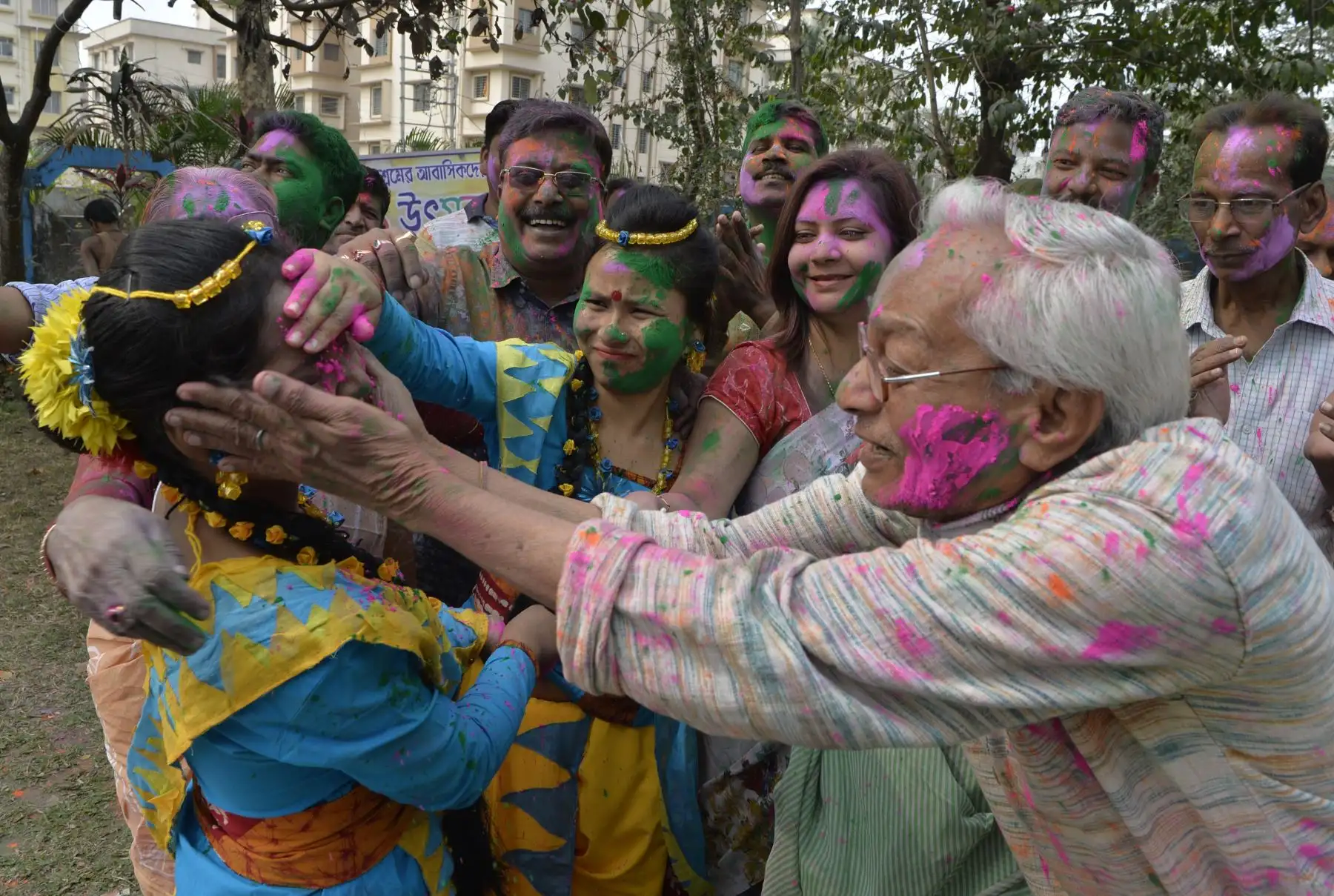Personas mayores de la India untan el polvo coloreado en una mujer para celebrar el festival hindú de Holi. Foto: AFP