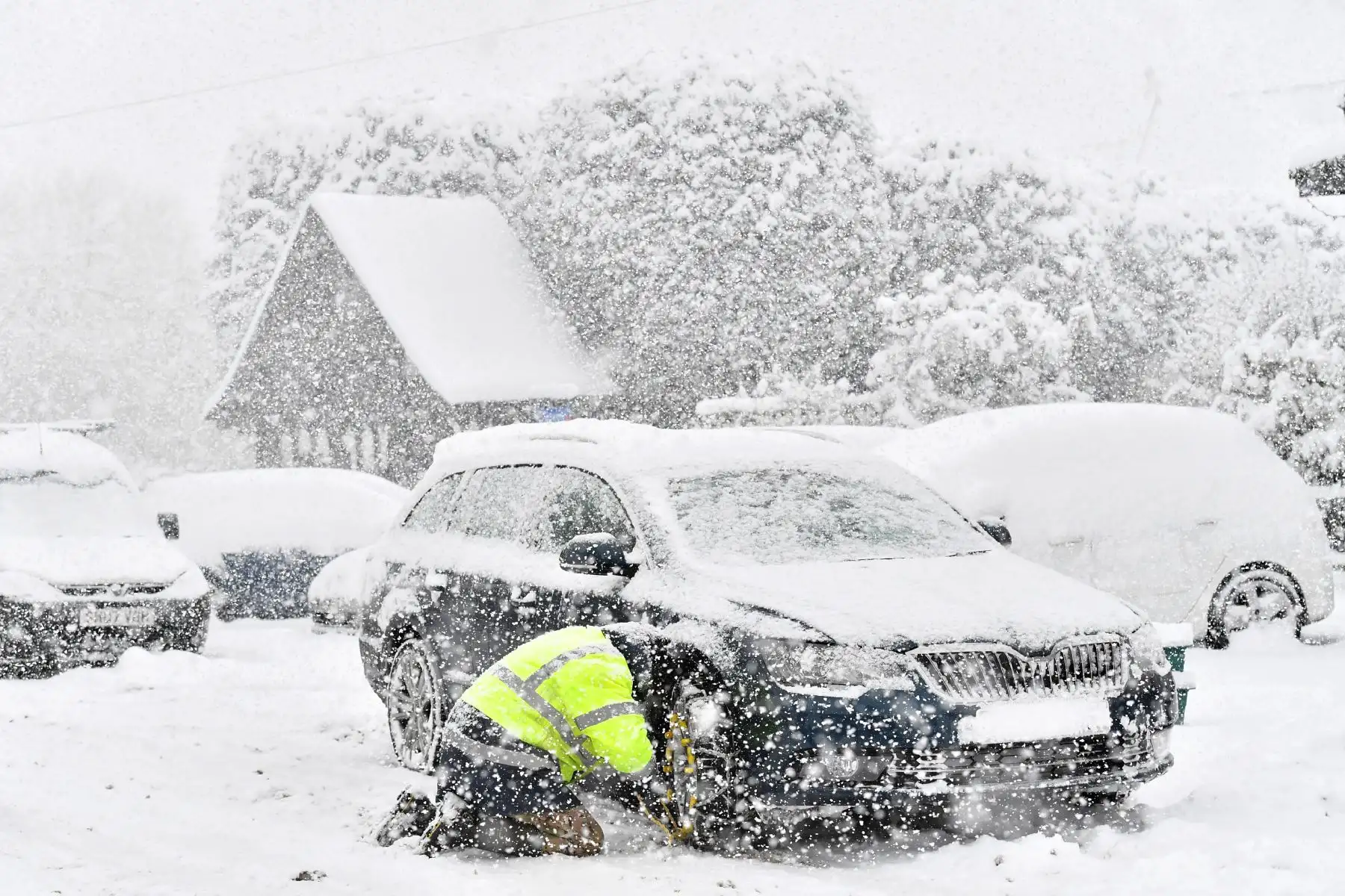 Un hombre acomoda cadenas para la nieve en su automóvil en la aldea de Brenchley, en el sudeste de Inglaterra. Foto: AFP