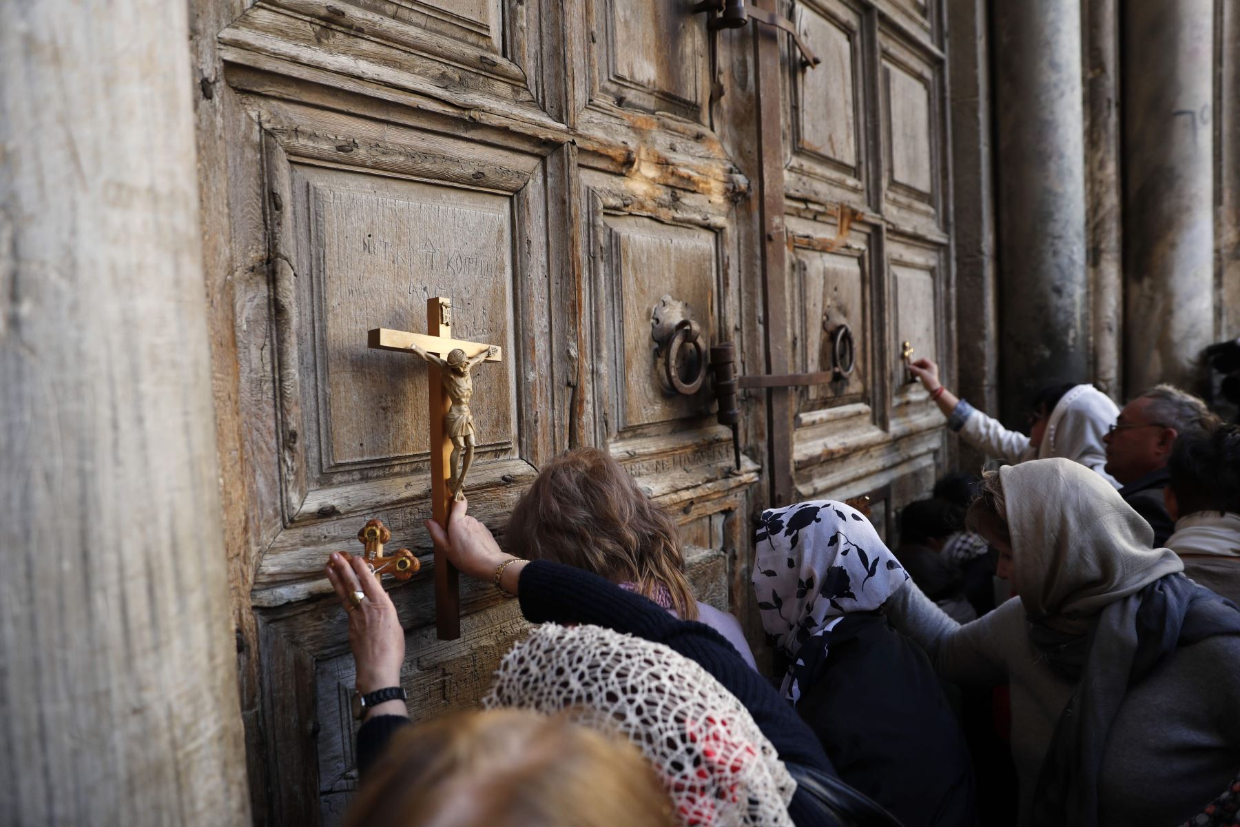 Peregrinos rezan frente a la puerta cerrada de la iglesia del Santo Sepulcro. Foto: AFP