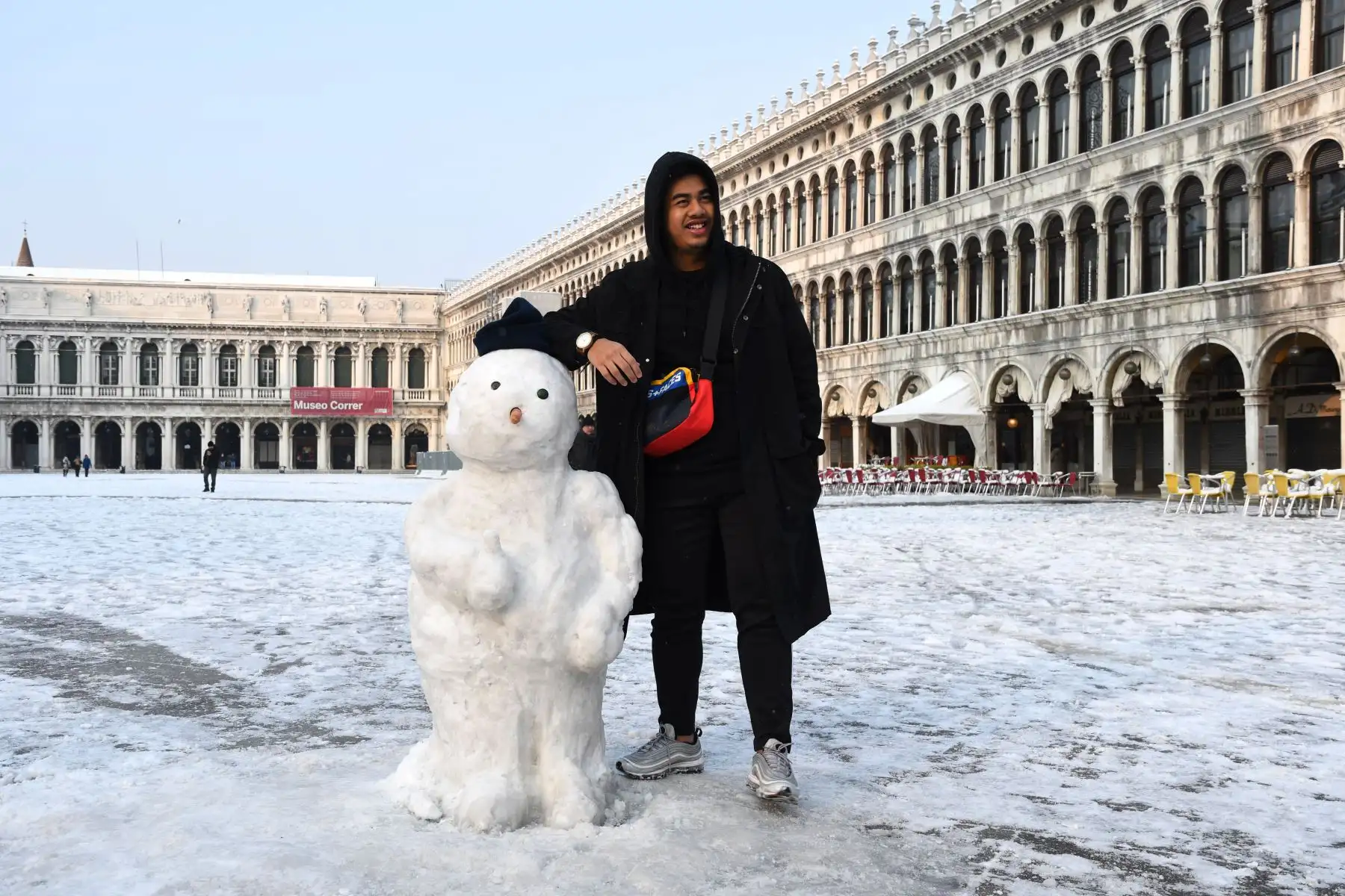 Un turista posa con un muñeco de nieve en Venecia. Foto: AFP