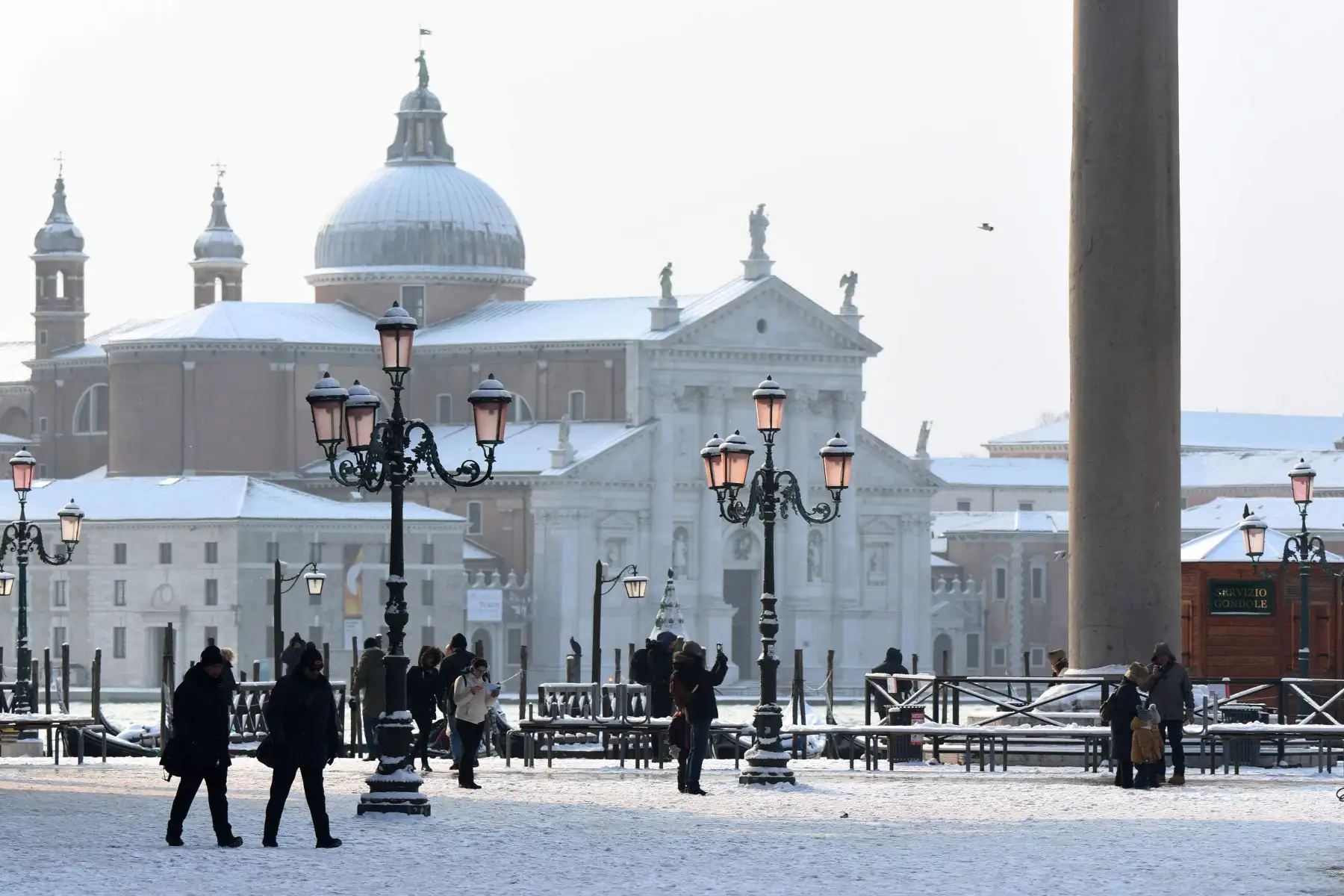 Turistas caminan por la Plaza de San Marcos cubierta de nieve en Venecia. Foto: AFP