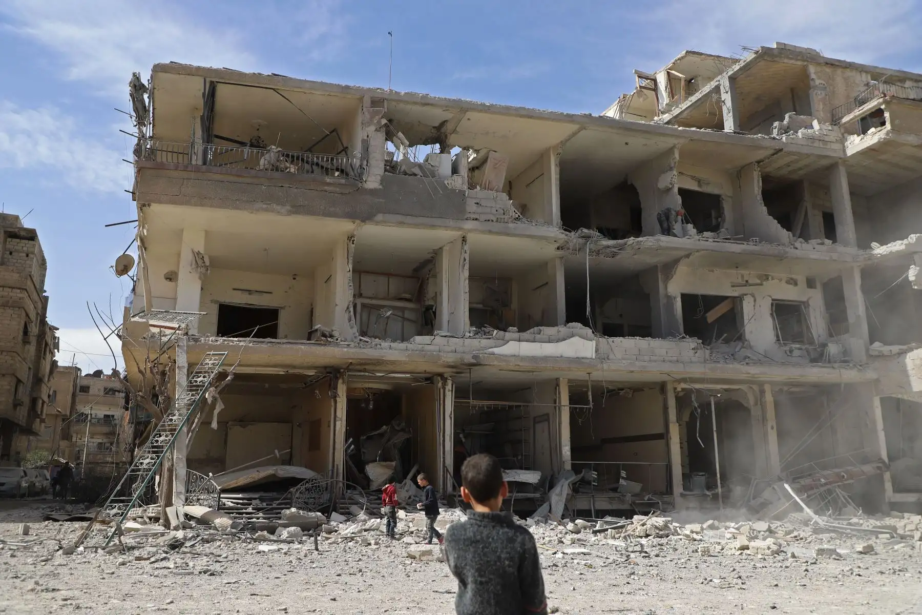 Niños sirios revisan los escombros  de un edificio destruido en Kafar Batna, en el enclave rebelde sirio de Ghouta Oriental, luego de los  ataques aéreos de las fuerzas del gobierno sirio. AFP