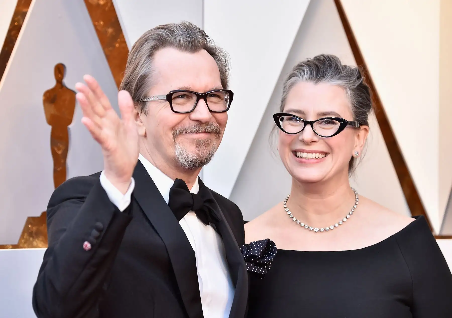 Gary Oldman y Gisele Schmidt saludan a su paso por la alfombra roja de los Premios Óscar. Foto: AFP