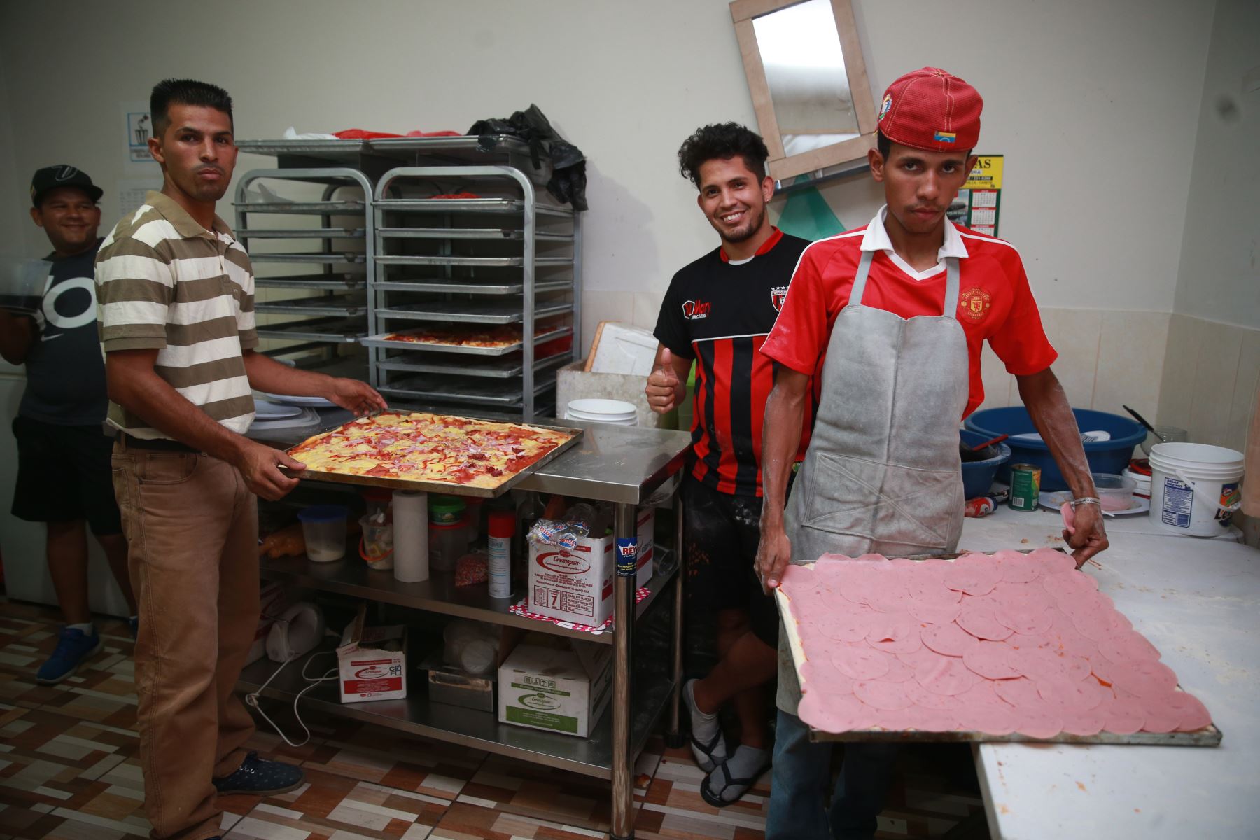 En el albergue de San Juan de Lurigancho preparan pizzas para vender y enviar remesas a sus parientes en Venezuela. Foto: ANDINA/Vidal Tarqui