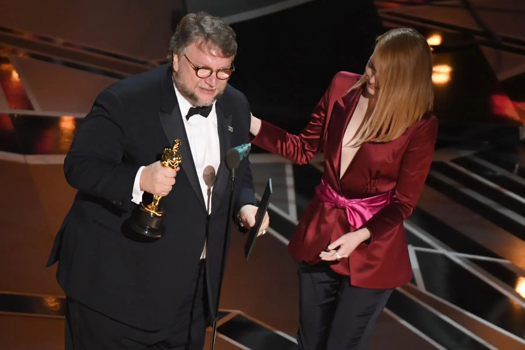 Guillermo del Toro recibe  de manos de la actriz Emma Stone el Óscar al mejor director por "The Shape of Water". Foto: AFP