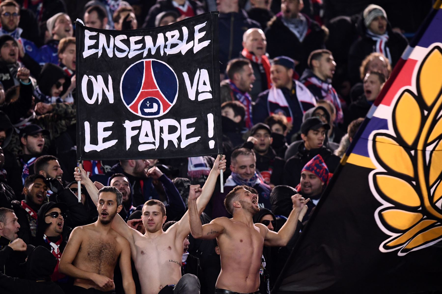 Partidarios del Paris Saint-Germain sostienen una pancarta que dice "Juntos lo haremos" en la ronda de octavos de final de la Liga de Campeones. Foto: AFP