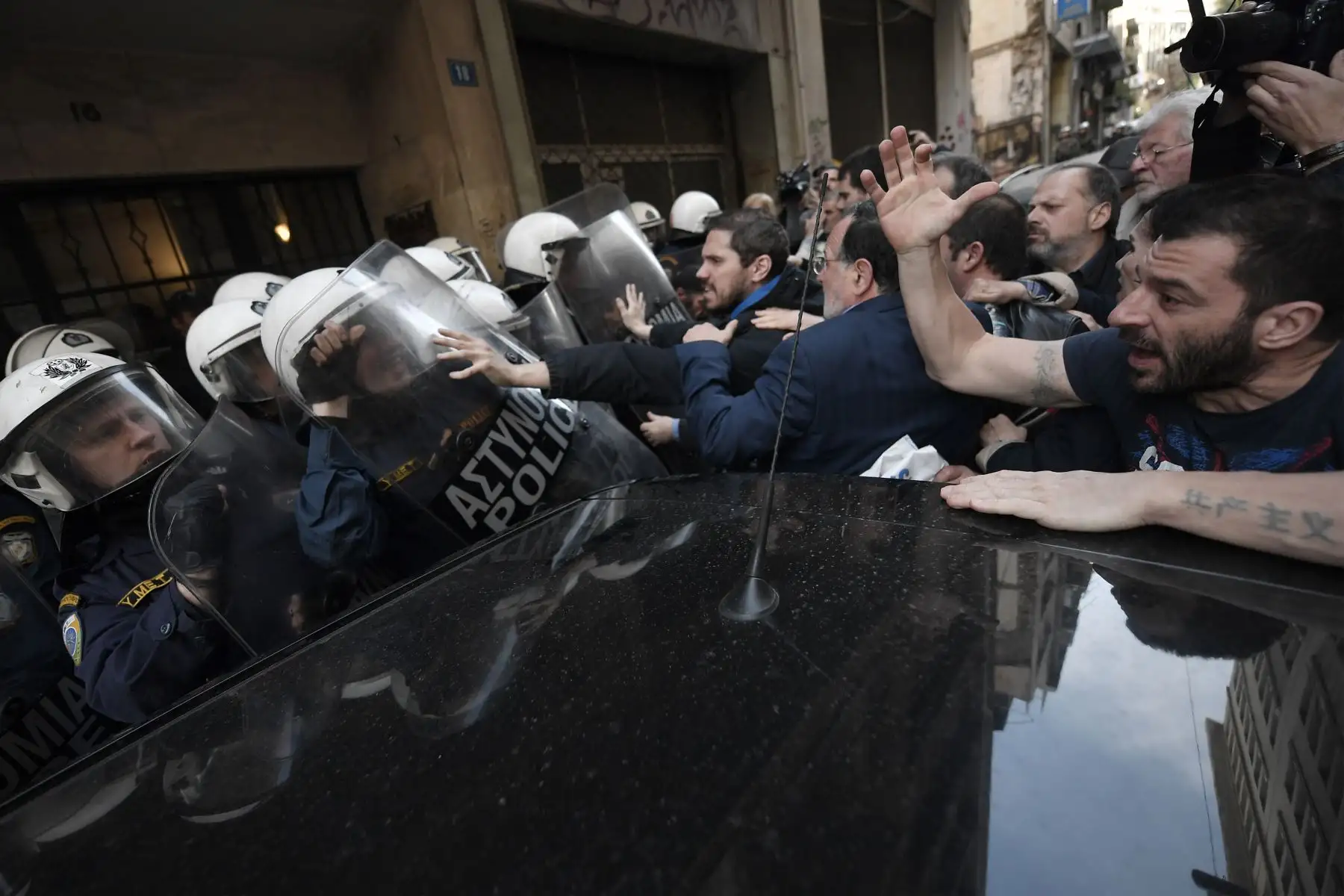 Manifestantes se enfrentan con la policía que custodia la entrada de una notaría pública en Atenas. Foto: AFP
