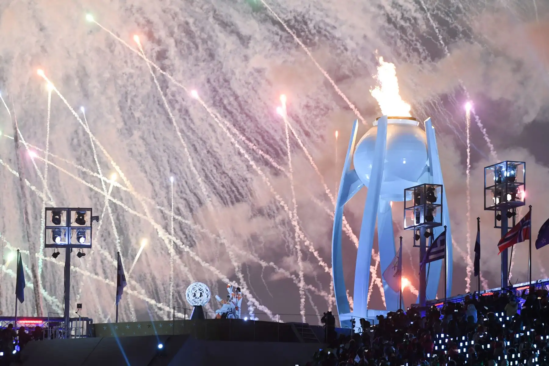 Fuegos artificiales explotan detrás del caldero paralímpico durante la ceremonia de inauguración. Foto: AFP