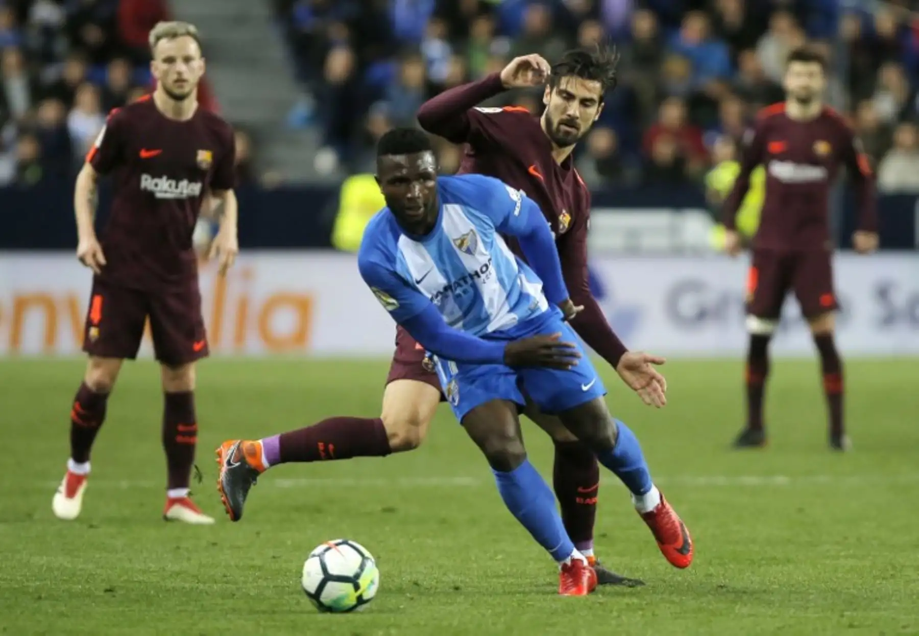 El delantero nigeriano del Málaga Isaac Success compite con el centrocampista portugués del Barcelona Andre Gomes durante el partido de fútbol de la liga española entre el Málaga CF y el FC Barcelona en el estadio La Rosaleda de Málaga. Foto: AFP