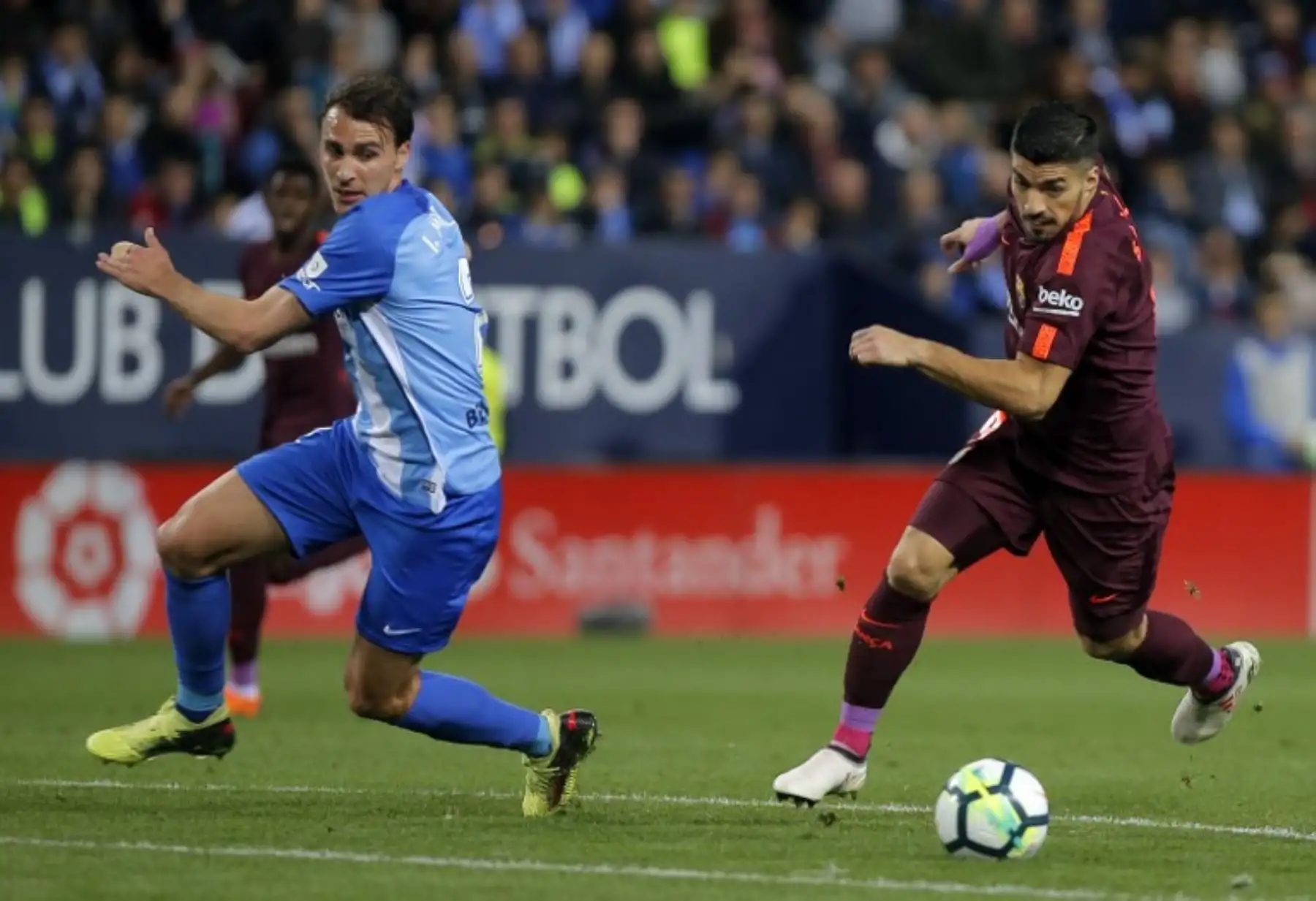 El defensa español del Málaga Ignasi Miquel compite con el delantero uruguayo del Barcelona Luis Suárez durante el partido de fútbol de la liga española.Foto:AFP