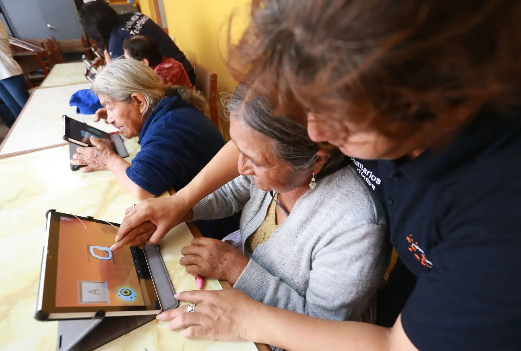 Abuelos quechua-hablantes del distrito de El Agustino aprenden a leer, escribir en español mediante el uso de tablets facilitadas por voluntaria de Telefónica del Perú. Foto: ANDINA/ Norman Córdova